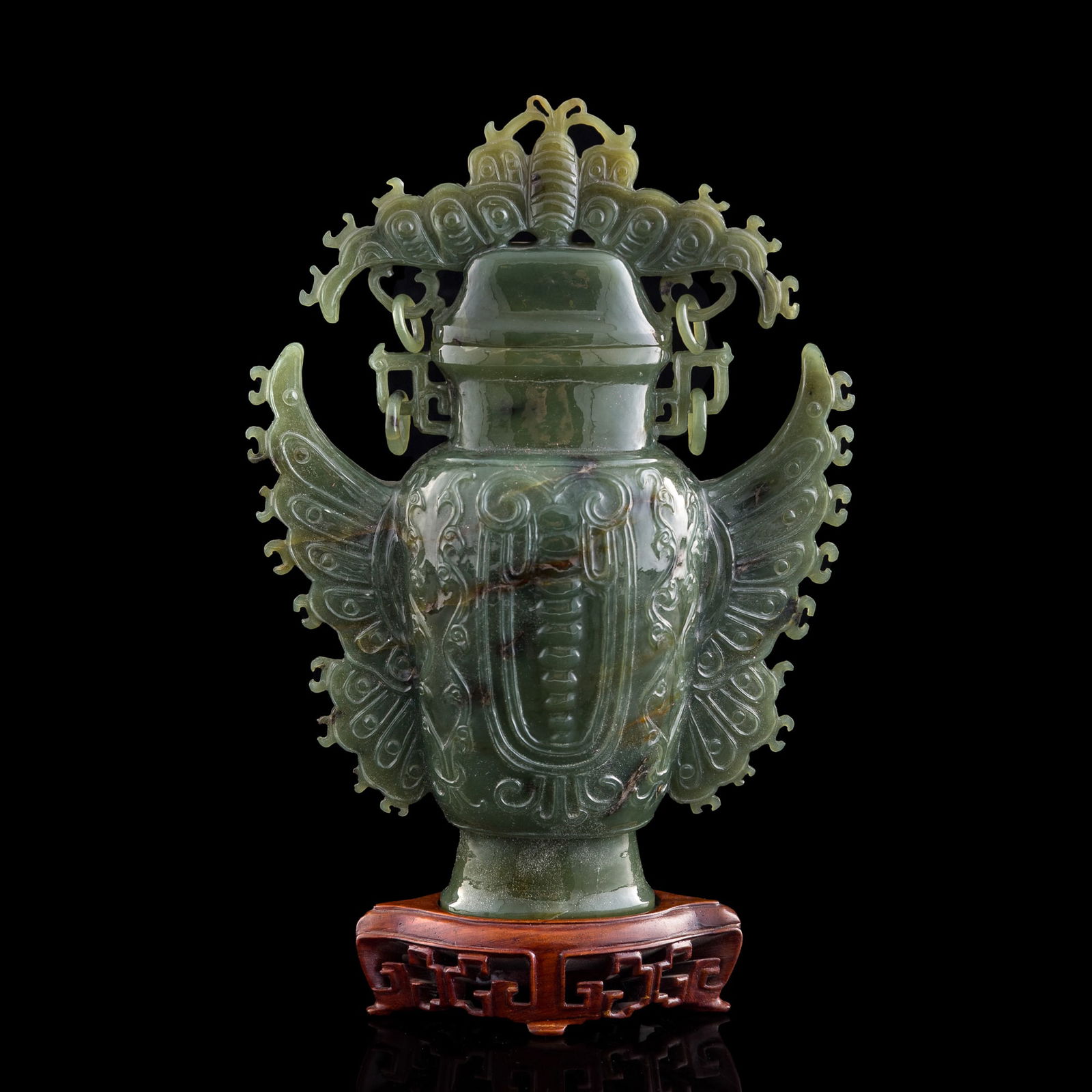 A Chinese celadon jade lidded vase: A Chinese celadon jade lidded vase Sold with associated wooden stand. H: 8 1/4, W: 6 1/8, D: 2 5/8 in. (H: 20.96, W: 15.56, D: 6.67 cm. (jade)) From a Florida private collection, assembled by a season