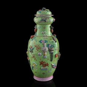 A Chinese green-ground famille rose 'hundred antiques' lidded vase, 19th century