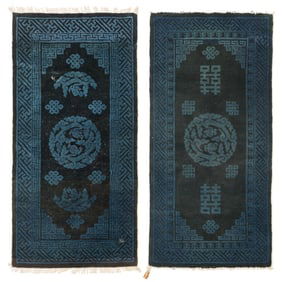 A pair of Chinese black-ground rugs with blue motifs, late 19th century