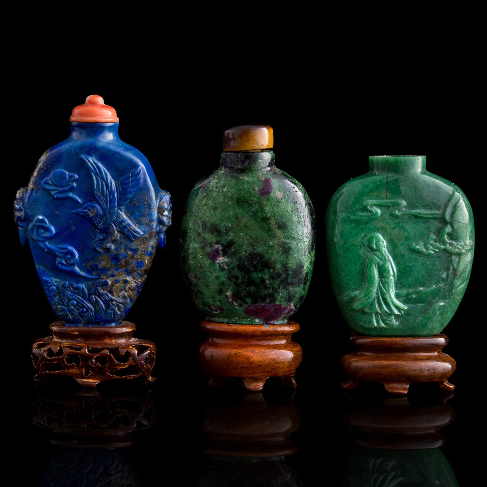 Three Chinese precious stone snuff bottles, early 20th century: Three Chinese precious stone snuff bottles early 20th century Sold with three associated stands and a coral stopper. (3). H: 2 5/8, W: 1 3/4, D: 5/8 in. (H: 6.67, W: 4.45, D: 1.59 cm. (largest)) Colle