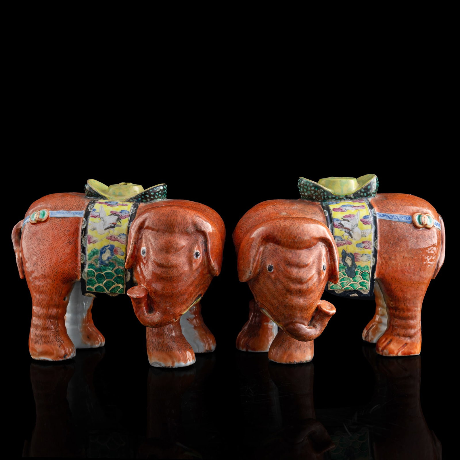 A pair of Chinese famille rose porcelain elephants, 19th century: A pair of Chinese famille rose porcelain elephants 19th century Each enameled in iron-red, fitted with a brightly colored saddlecloth decorated with cranes, clouds, and wave motifs. (2). H: 7 1/8, W: 