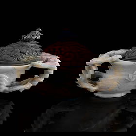 A Chinese chicken-bone white jade cup with chilong handles, Ming dynasty: A Chinese chicken-bone white jade cup with chilong handles Ming dynasty Sold with original hardwood cover. H: 2 3/4, W: 4 3/8, D: 2 1/2 in. (H: 6.99, W: 11.11, D: 6.35 cm. (overall)) Private collectio