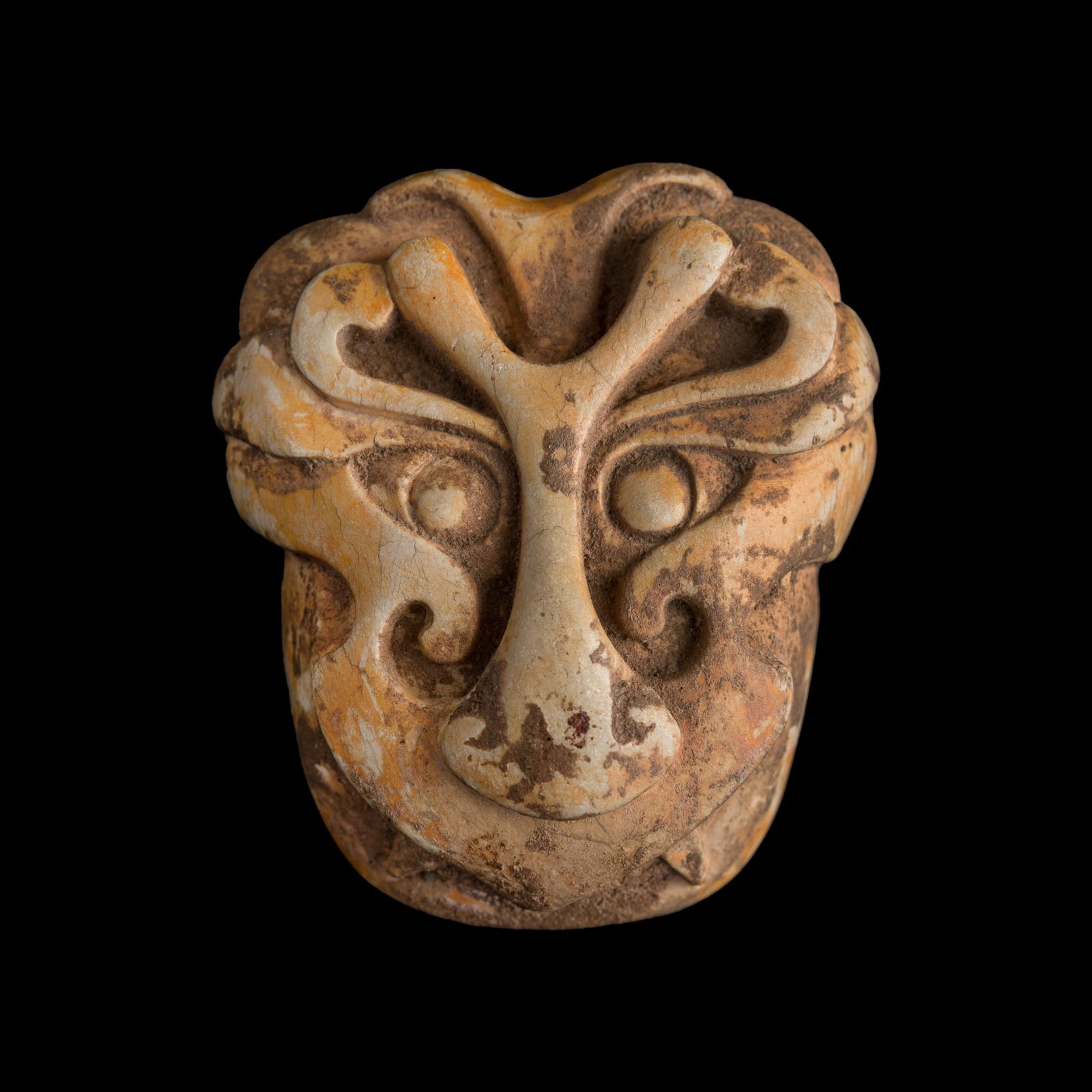 A Chinese chicken bone jade carving of a mask, Tang dynasty or earlier: A Chinese chicken bone jade carving of a maskTang dynasty or earlierH: 2 3/4, W: 2 3/8, D: 1 1/8 in. (H: 7, W: 6, D: 2.9 cm.)From Mrs. Fullerton in New Jersey. Her father, Maurice Etangs, was chief