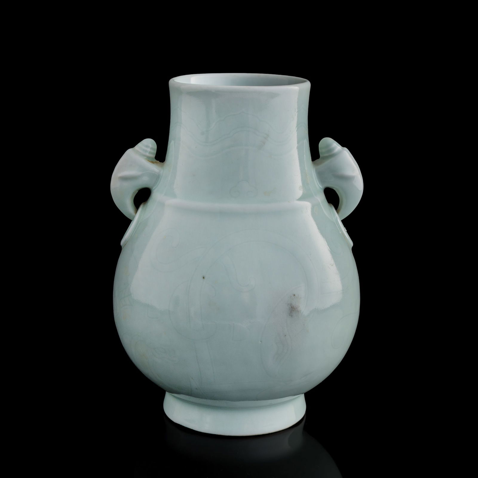 A Chinese celadon-glazed double-handled vase, Qing dynasty: A Chinese celadon-glazed double-handled vaseQing dynastyDecorated with light incised scrollwork throughout. With a six-character mark to the underside. Accompanied by a handwritten letter.H: 8, Dia: