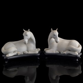 A pair of Chinese bisque porcelain recumbent horses, Republic period