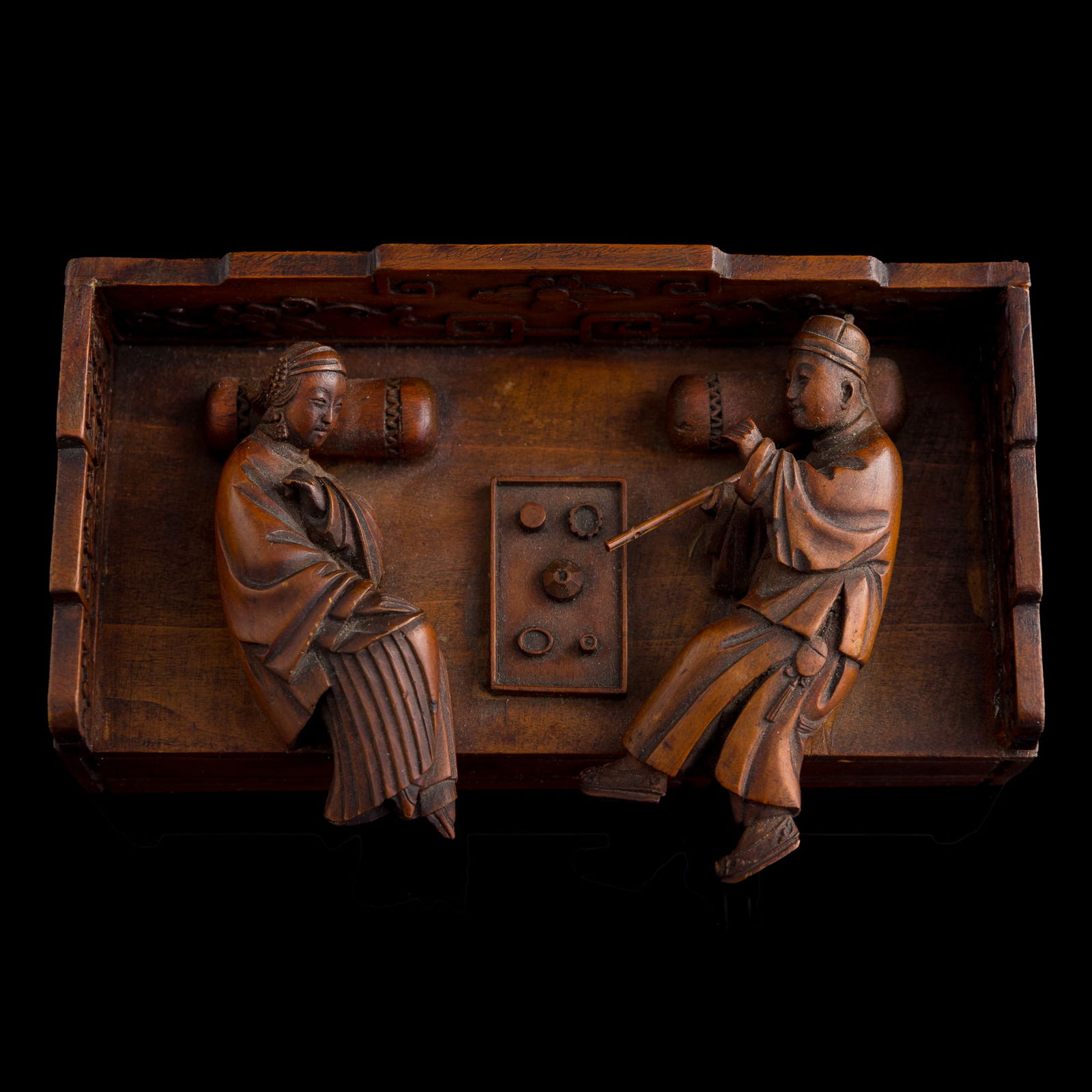 A Chinese wood carving of two reclining opium smokers, late 19th century: A Chinese wood carving of two reclining opium smokers late 19th century H: 2 1/2, W: 6 3/8, D: 3 7/8 in. (H: 6.4, W: 16.2, D: 9.8 cm.) From Mrs. Budow of Marietta, Georgia; inherited from her grandfat