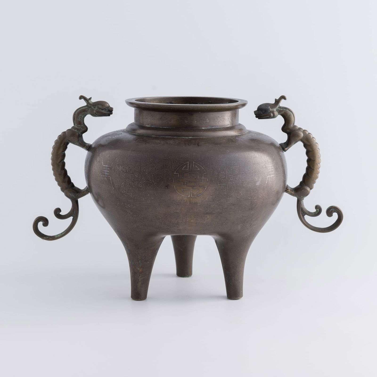 A Chinese bronze tripod censer, Qing dynasty: A Chinese bronze tripod censerQing dynastyWith silver-inlaid chilong handles, a "Shi Sou" mark to the underside.H: 8 3/4, W: 13 5/8, D: 8 3/4 in. (H: 22.2, W: 34.6, D: 22.2 cm.)Weight: 2944 gFrom Mr.