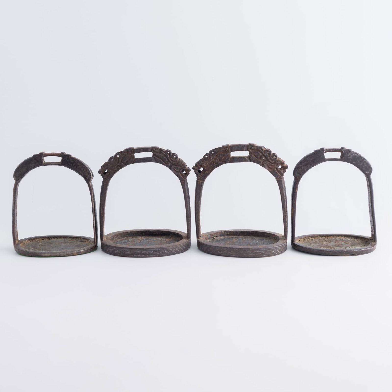 Two pairs of Chinese silver-inlaid iron horse stirrups, Ming/Qing dynasty: Two pairs of Chinese silver-inlaid iron horse stirrupsMing/Qing dynastyOne pair decorated with dragon heads to the top arches. (4).H: 6 1/8, W: 5 3/8, D: 4 1/2 in. (H: 15.6, W: 13.7, D: 11.4 cm.