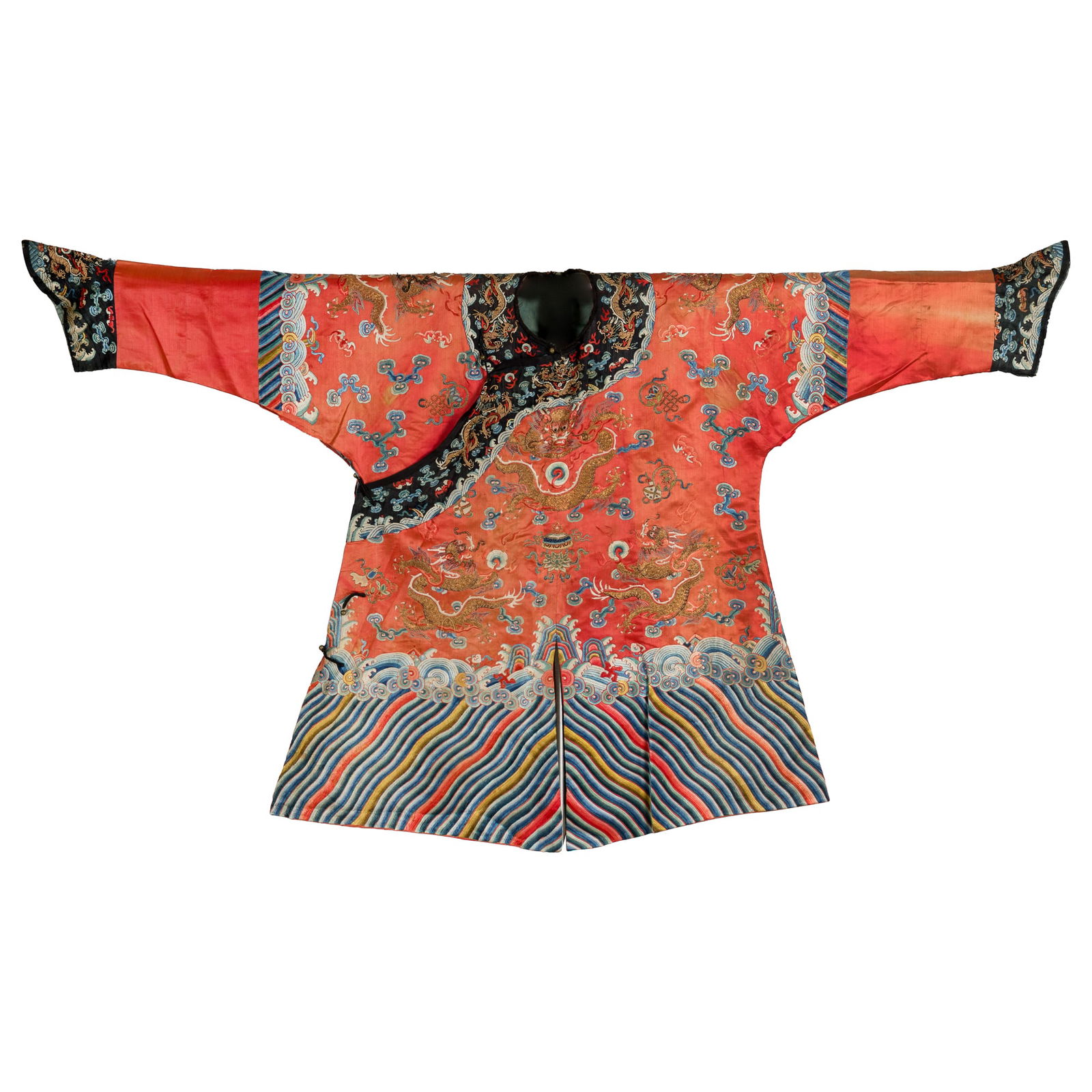 A Chinese red-ground gold-thread embroidered dragon robe, 19th century: A Chinese red-ground gold-thread embroidered dragon robe 19th century Decorated with five-clawed dragons amid clouds and flames, interspersed with scattered auspicious emblems. The hem is bordered wit