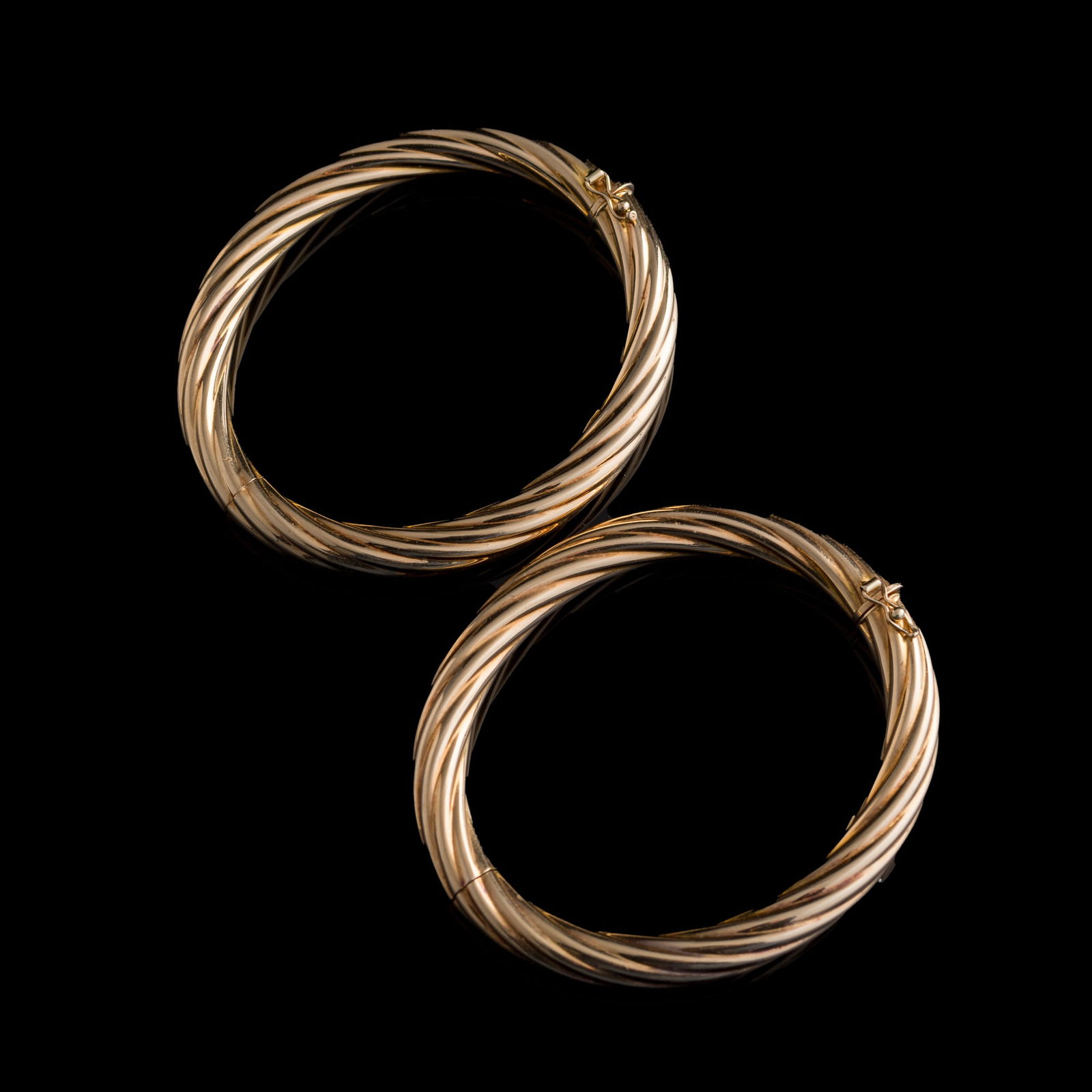 A pair of 14K gold Italian hollow bangles: A pair of 14K gold Italian hollow bangles Each marked 14K and ITALY, with additional BREV. patent mark. (2). Outer Dia: 3 in. (7.6 cm.), Inner Dia: 2 3/8 in. (6 cm.) Weight: 33.9 g (overall) Private c