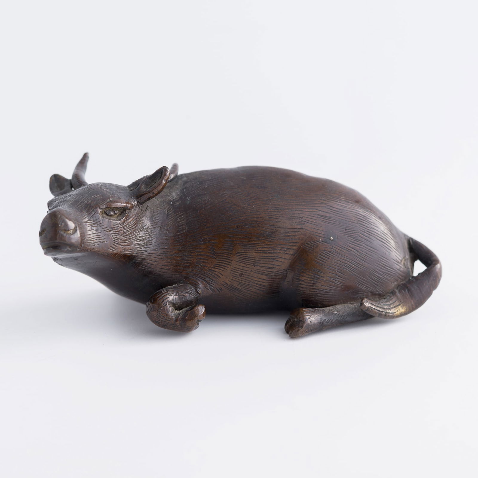 A Chinese bronze ox-form paperweight, Qing dynasty (1 of 7)