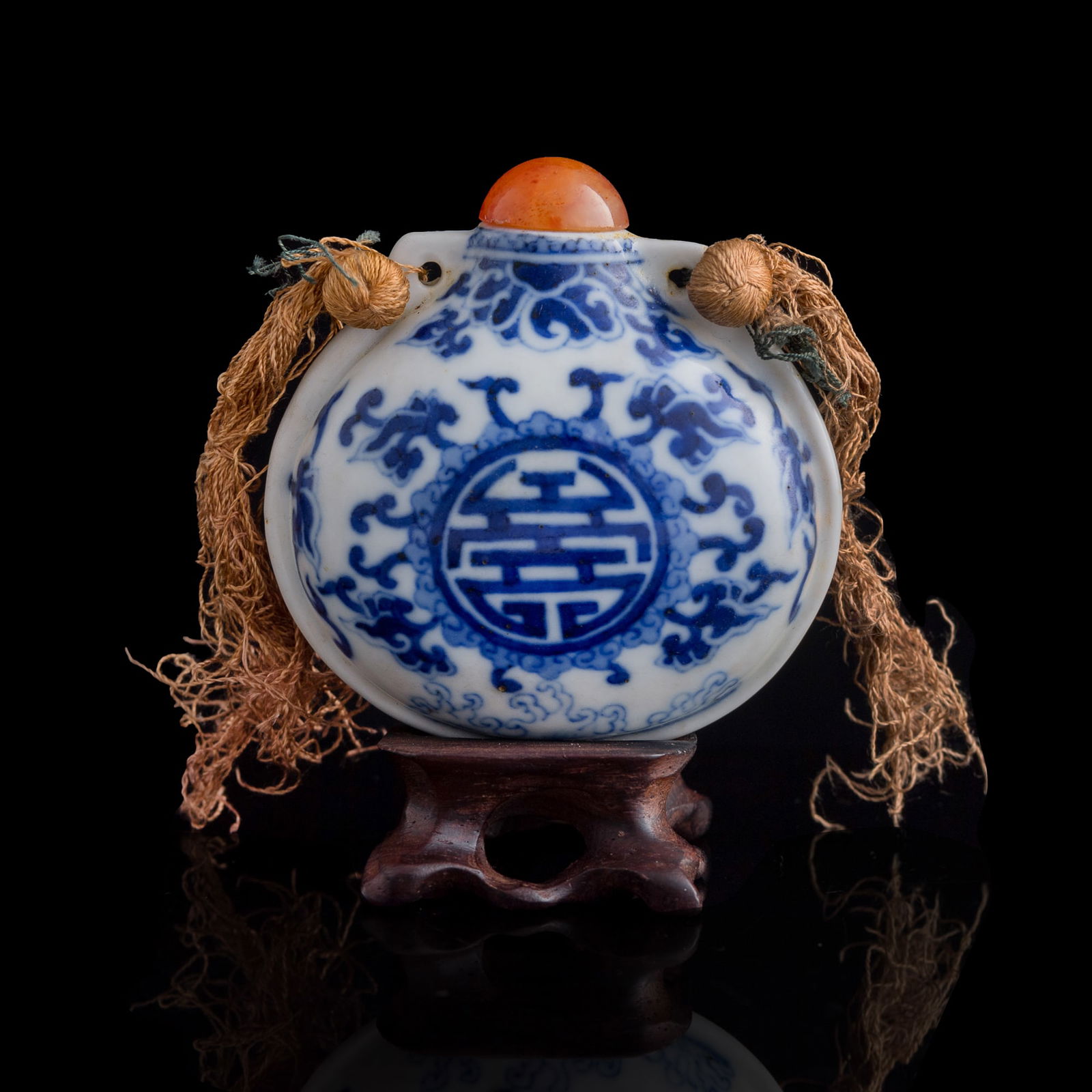 A Chinese blue and white sack-form snuff bottle, 19th century: A Chinese blue and white sack-form snuff bottle 19th century Decorated with a ‘shou’ roundel surrounded by lingzhi and ruyi motifs, resembling a bright sun rising above the sea. Sold with associat