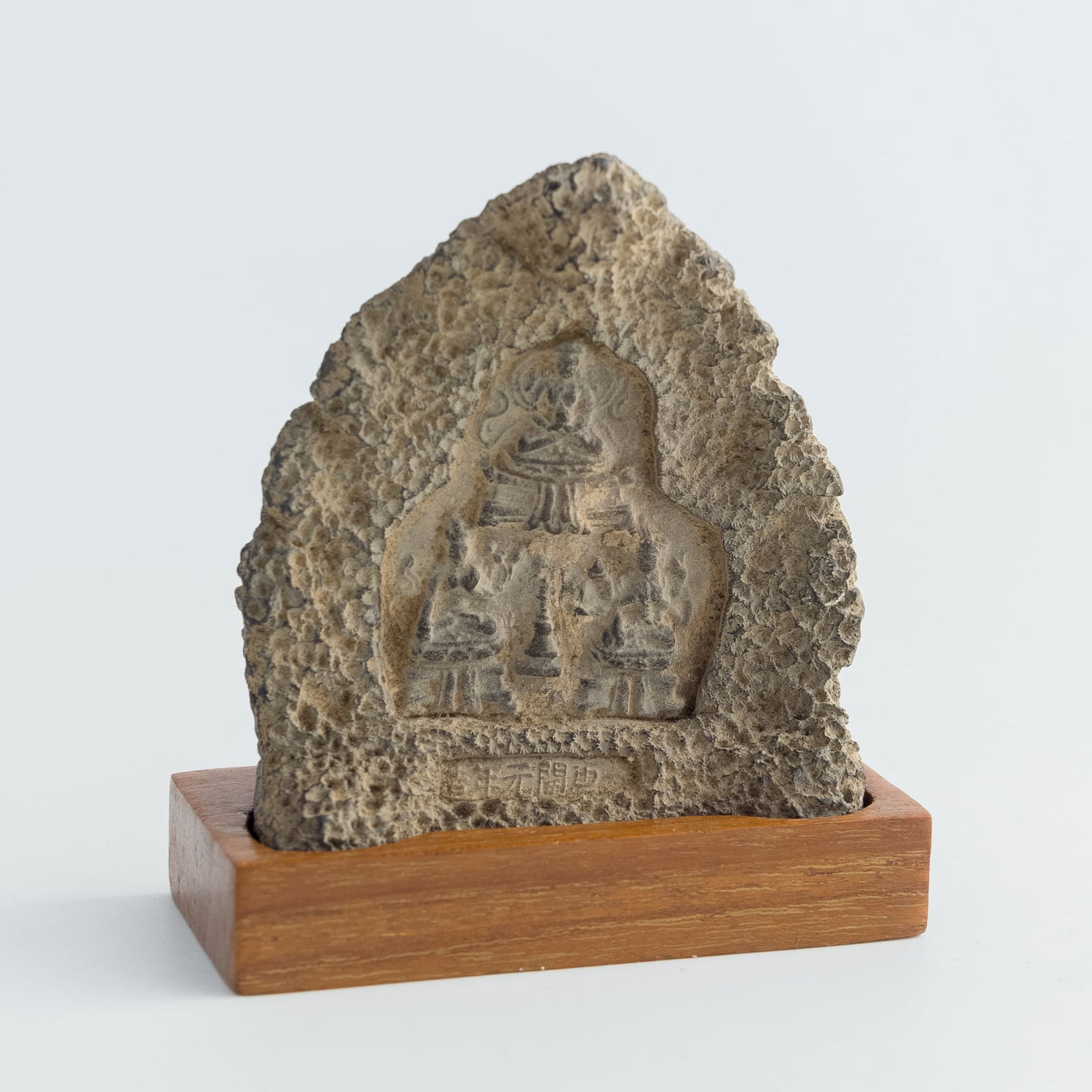 A pottery Buddhist shrine: A pottery Buddhist shrine Sold with associated wooden stand. H: 2 3/4, W: 2 1/2, D: 1 1/8 in. (H: 7, W: 6.4, D: 2.9 cm. (shrine)) From Dr. Lau, Honolulu, Hawaii. Acquired in Hong Kong in the 1970s to
