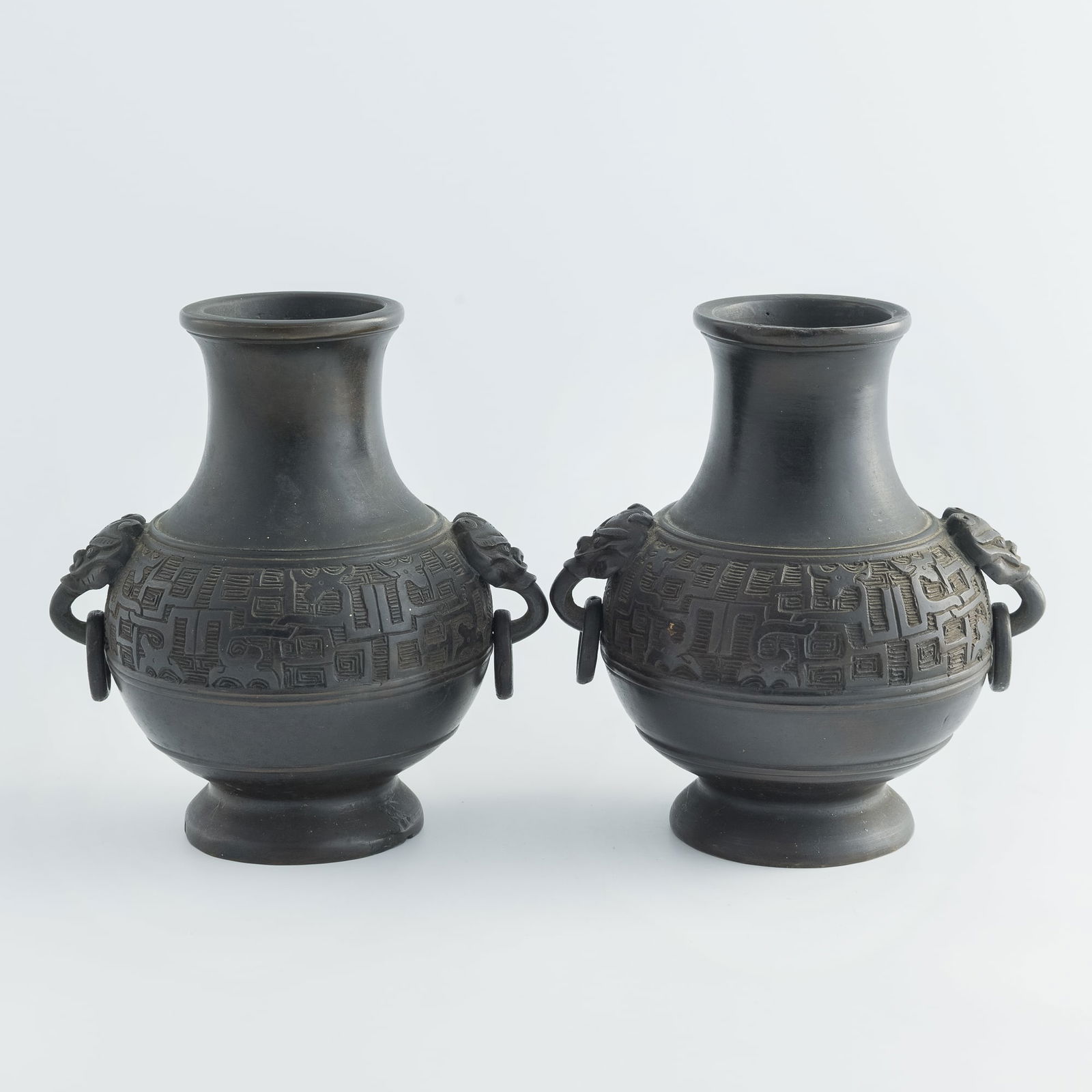 A pair of Chinese bronze vessels with taotie-mask handles, Qing dynasty: A pair of Chinese bronze vessels with taotie-mask handlesQing dynastyH: 6 7/8, W: 6 1/8, D: 4 7/8 in. (H: 17.5, W: 15.6, D: 12.4 cm. (each))Weight: 3250 g (overall)Private collection, Malvern,