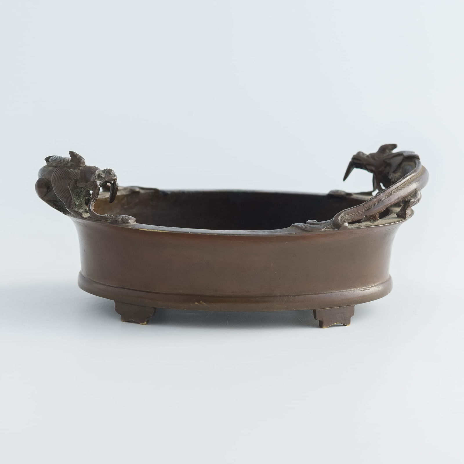 A Chinese bronze censer with chilong handles, 18th century: A Chinese bronze censer with chilong handles18th centuryWith six-character mark to underside.H: 2 5/8, W: 6 3/8, D: 4 5/8 in. (H: 6.7, W: 16.2, D: 11.7 cm.)Weight: 627 gFrom Mr. Kirk in Richmond,