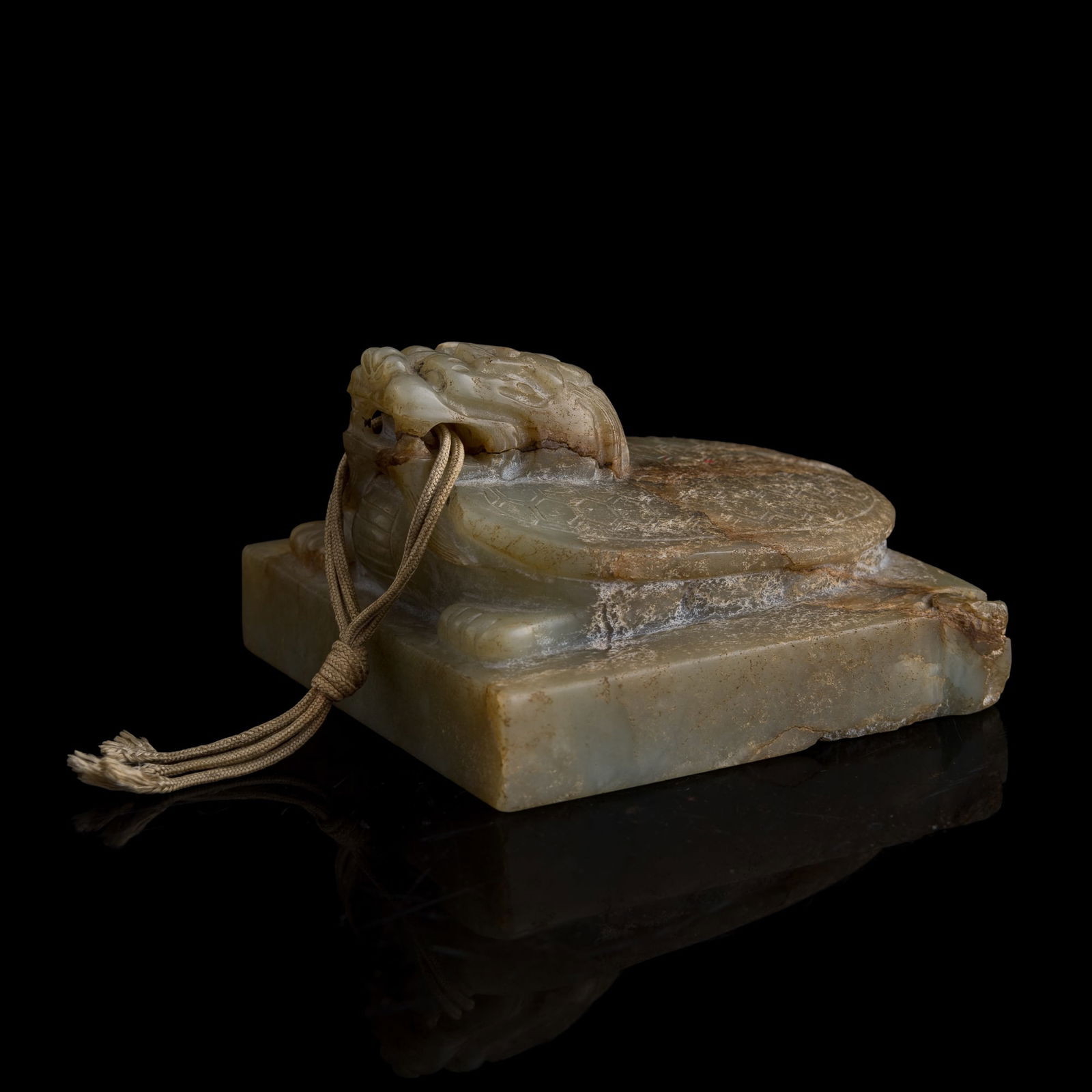 A Chinese jade seal with dragon-tortoise finial, Ming dynasty: A Chinese jade seal with dragon-tortoise finial Ming dynasty Surmounted by a finely carved dragon-tortoise (bi xi) with its shell rendered with incised hexagonal patterning. The seal is carved from pa