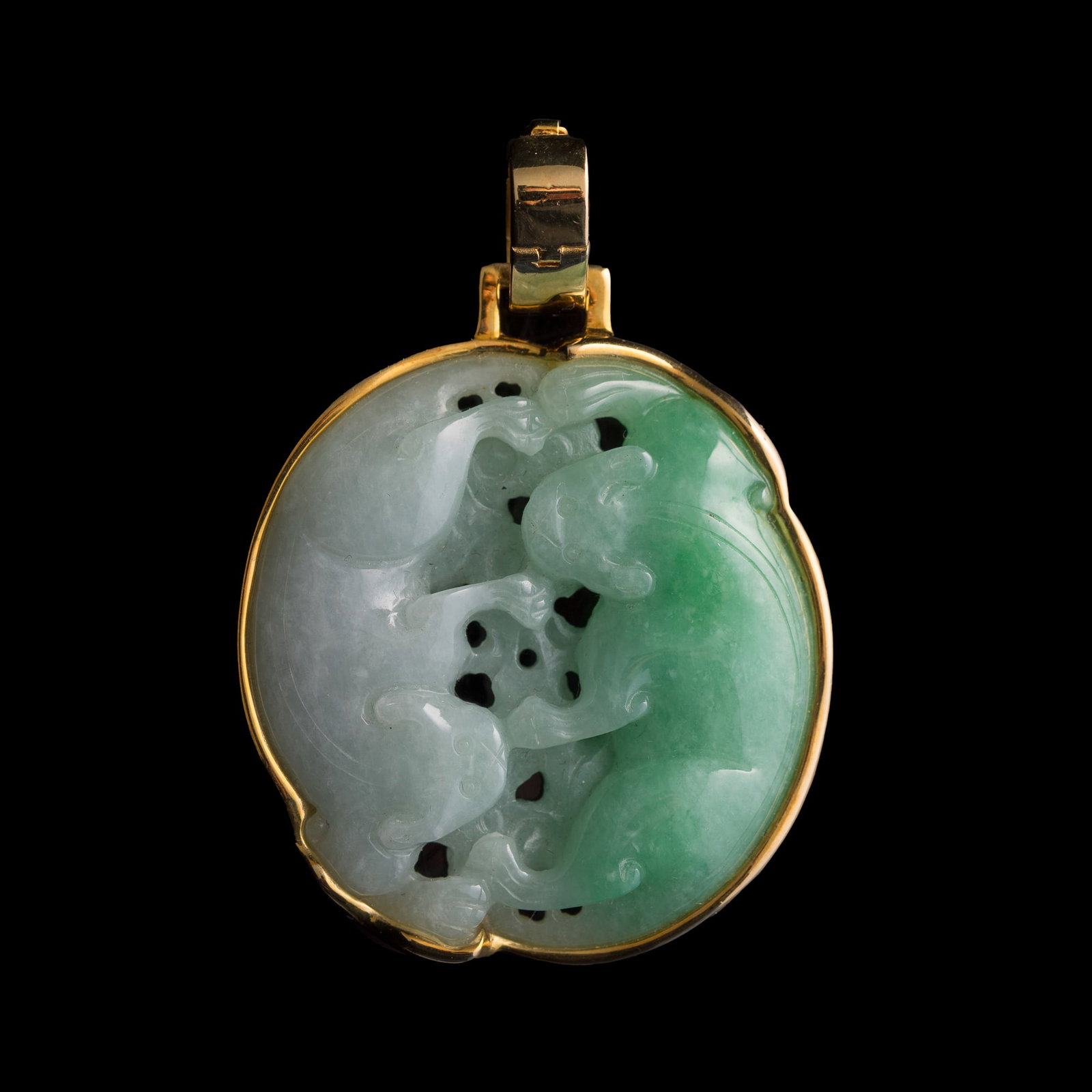 A Chinese jadeite 'double badger' pendant with metal mounts, 19th century: A Chinese jadeite 'double badger' pendant with metal mounts 19th century With "14K" and another stamp mark to the clasp. H: 2 1/4, W: 1 3/4, D: 3/8 in. (H: 5.7, W: 4.4, D: 1 cm.) Weight: 42.42 g From 