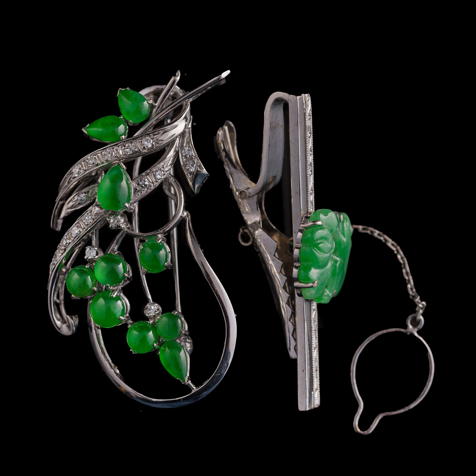 A Chinese jadeite-set white metal brooch and a tie clip,: A Chinese jadeite-set white metal brooch and a tie clip Each with "14K" stamp mark to verso. (2). H: 1 7/8, W: 1, D: 1/2 in. (H: 4.8, W: 2.5, D: 1.3 cm. (largest)) Weight: 15.48 g (overall) From Mr. L
