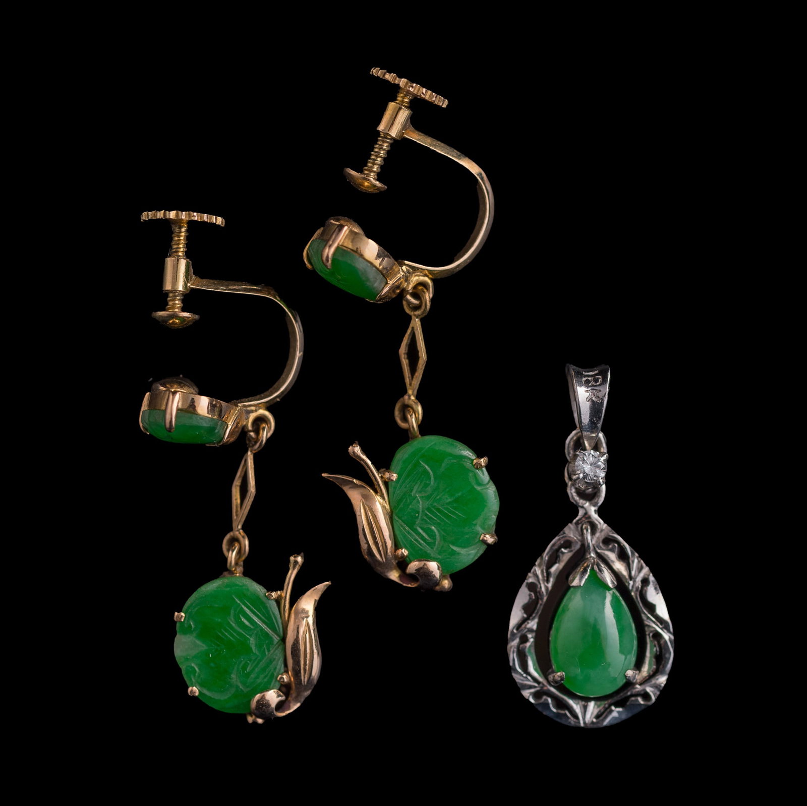 A pair of Chinese jadeite-set metal earrings and a pendant,: A pair of Chinese jadeite-set metal earrings and a pendant Pendant with "18K" stamp mark to the bail, one earring with "14K" stamp mark to the earring back. (3). H: 1 1/8, W: 3/8, D: 5/8 in. (H: 2.9, 