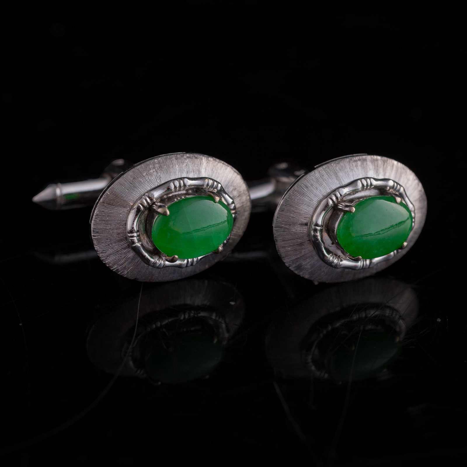 A pair of Chinese jadeite-set white metal cufflinks,: A pair of Chinese jadeite-set white metal cufflinks Each with "PARIS" and "14K" stamp marks. (2). H: 7/8, W: 3/4, D: 1/2 in. (H: 2.2, W: 1.9, D: 1.3 cm. (each)) Weight: 12.26 g (overall) Private colle
