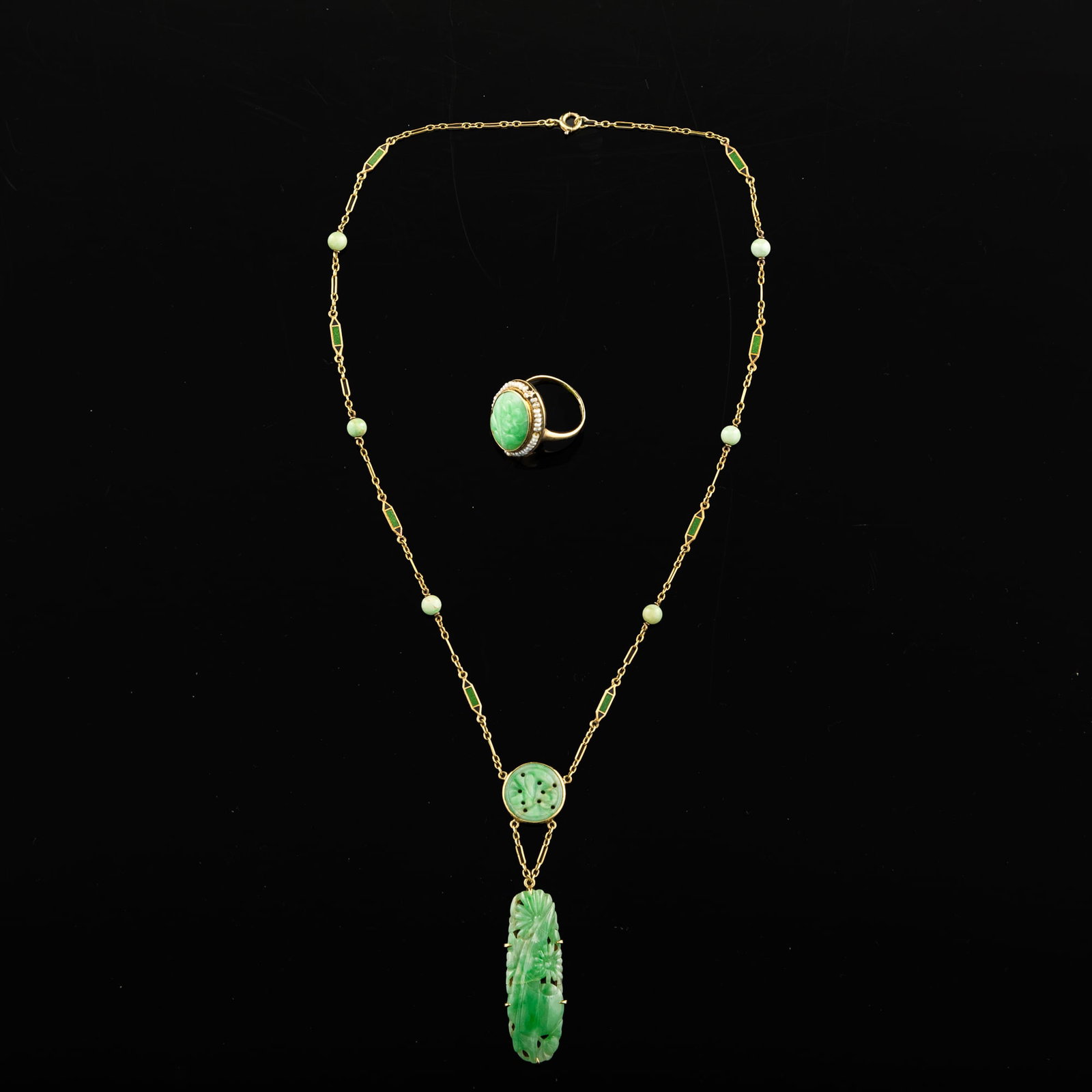 A Chinese jadeite necklace and a jadeite-set ring, Republic period: A Chinese jadeite necklace and a jadeite-set ring Republic period Ring with "14K" and "KB" marks to band interior. (2). Necklace length: 10 5/8 in. (27 cm.), Pendant: H: 1 5/8, W: 1/2, D: 1/8 in. (H: 