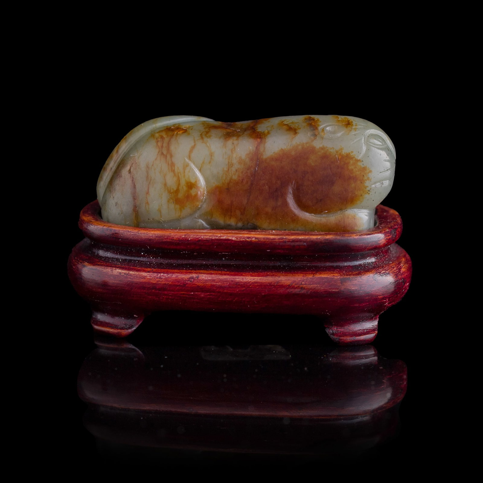 A Chinese jade carving of a beast with russet skin, Ming dynasty: A Chinese jade carving of a beast with russet skin Ming dynasty Sold with associated wooden stand. H: 3/4, W: 2, D: 7/8 in. (H: 1.9, W: 5.1, D: 2.2 cm. (jade)) Private collection, Florida.