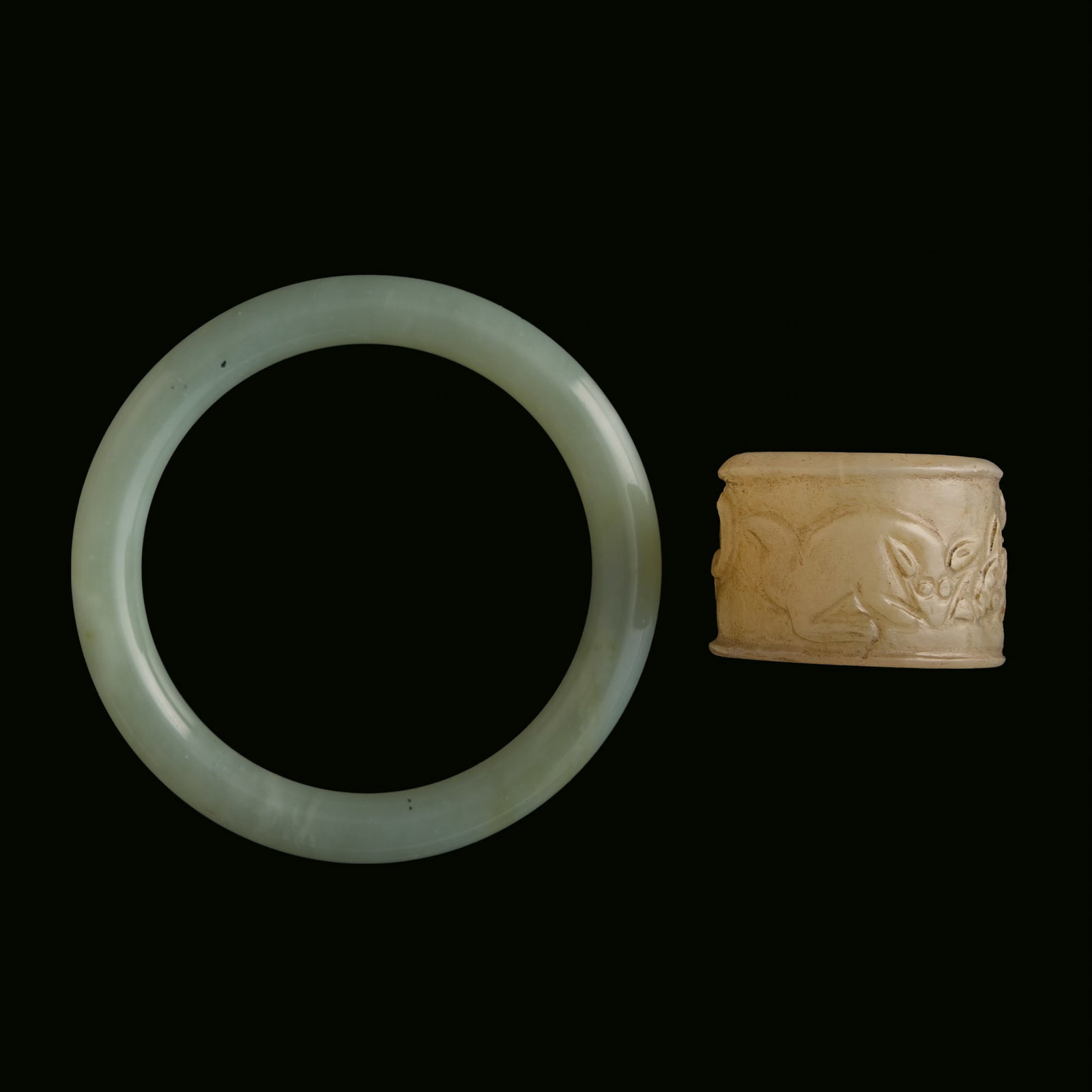 A Chinese jade bangle and a jade archer's ring, Qing dynasty: A Chinese jade bangle and a jade archer's ring Qing dynasty Bangle: Inner Dia.: 60 mm, D: 9.4 mm Ring: Inner Dia: 22.9 mm, H: 26.4 mm Private collection, Fremont, California.