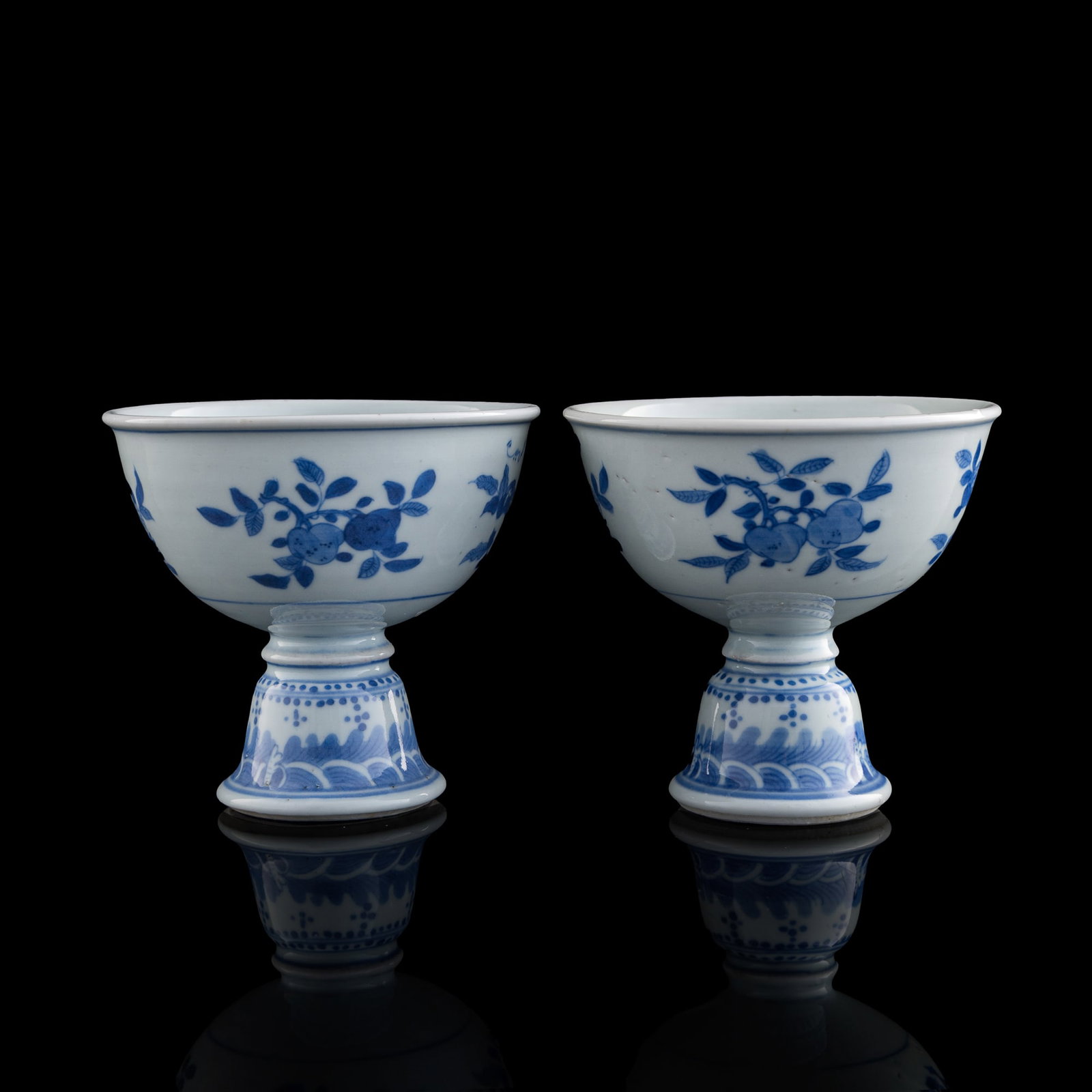 A pair Chinese of blue and white high-stem cups, early 17th century: A pair Chinese of blue and white high-stem cups early 17th century One with previous collector's sticker to interior. (2). H: 4 7/8, Dia: 5 1/8 in. (H: 12.4, Dia: 13 cm. (each)) Private collection, Ro