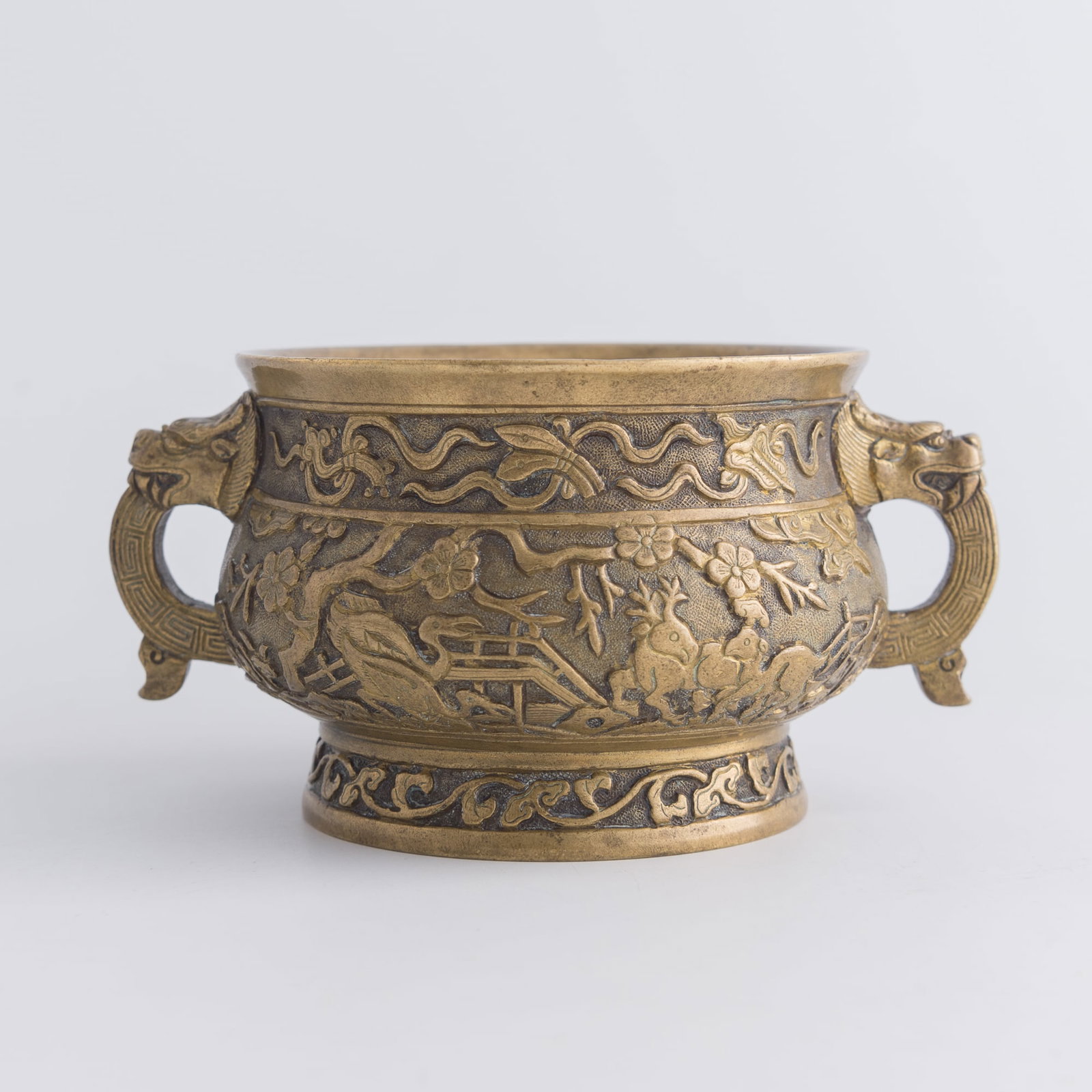 A Chinese bronze 'crane and deer' gui-form censer, Qing dynasty: A Chinese bronze 'crane and deer' gui-form censer Qing dynasty With "Hu Wenming zhi" mark to underside and decorated with two dragon handles. H: 2 7/8, W: 5 1/2, D: 4 in. (H: 7.3, W: 14, D: 10.2 cm.) 