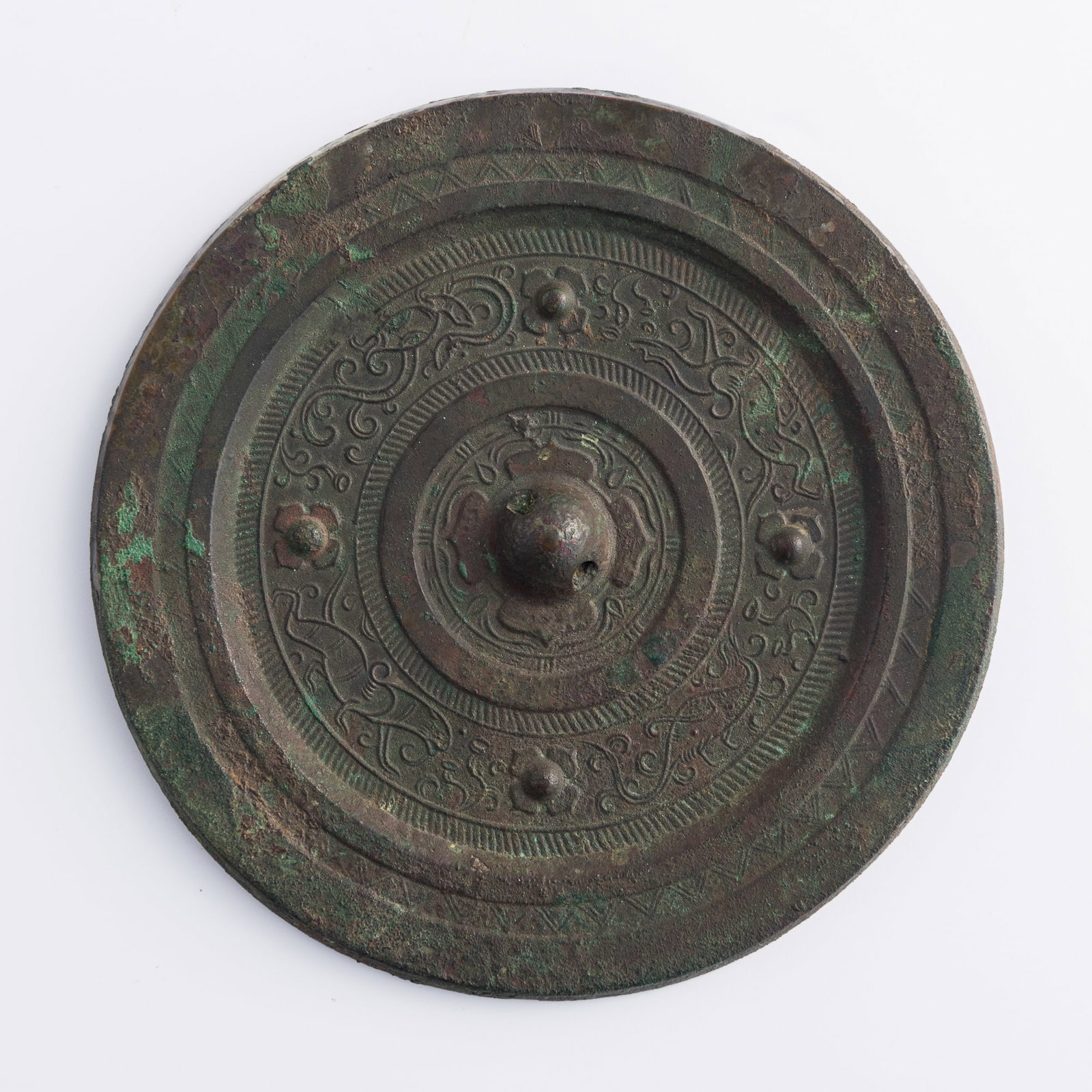 A Chinese bronze mirror, Han dynasty: A Chinese bronze mirror Han dynasty With a band of four mythical creatures on the reverse. Dia: 5 1/4, D: 1/4 in. (Dia: 13.3, D: 0.6 cm.) Weight: 429.8 g Private collection, Rowland Heights, Californi