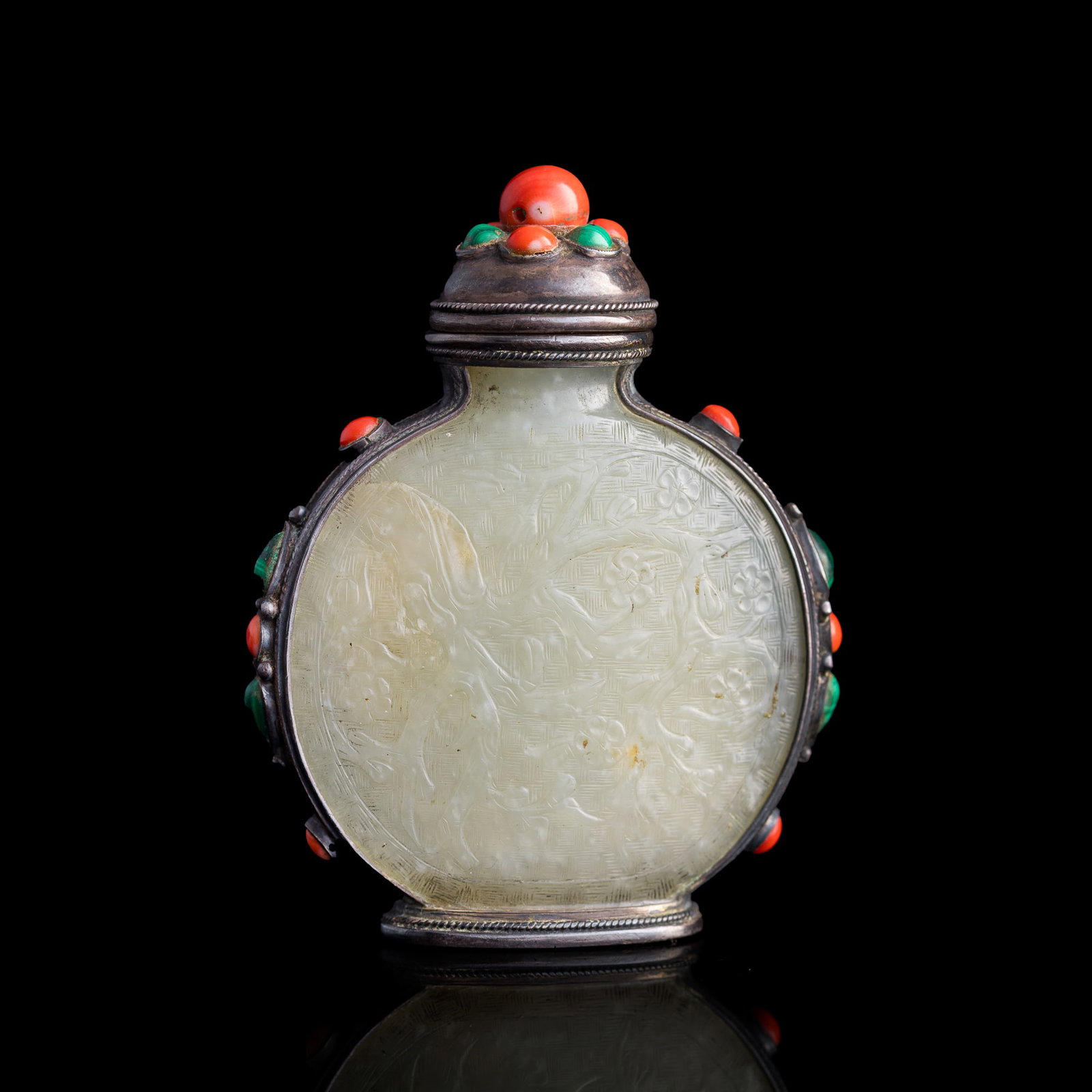A Chinese silver-encased jade snuff bottle, 18th/19th century: A Chinese silver-encased jade snuff bottle 18th/19th century Uses the bezel setting technique that holds gemstones within a continuous band of silver. H: 3 1/4, W: 2 1/2, D: 1 in. (H: 8.3, W: 6.4, D: 
