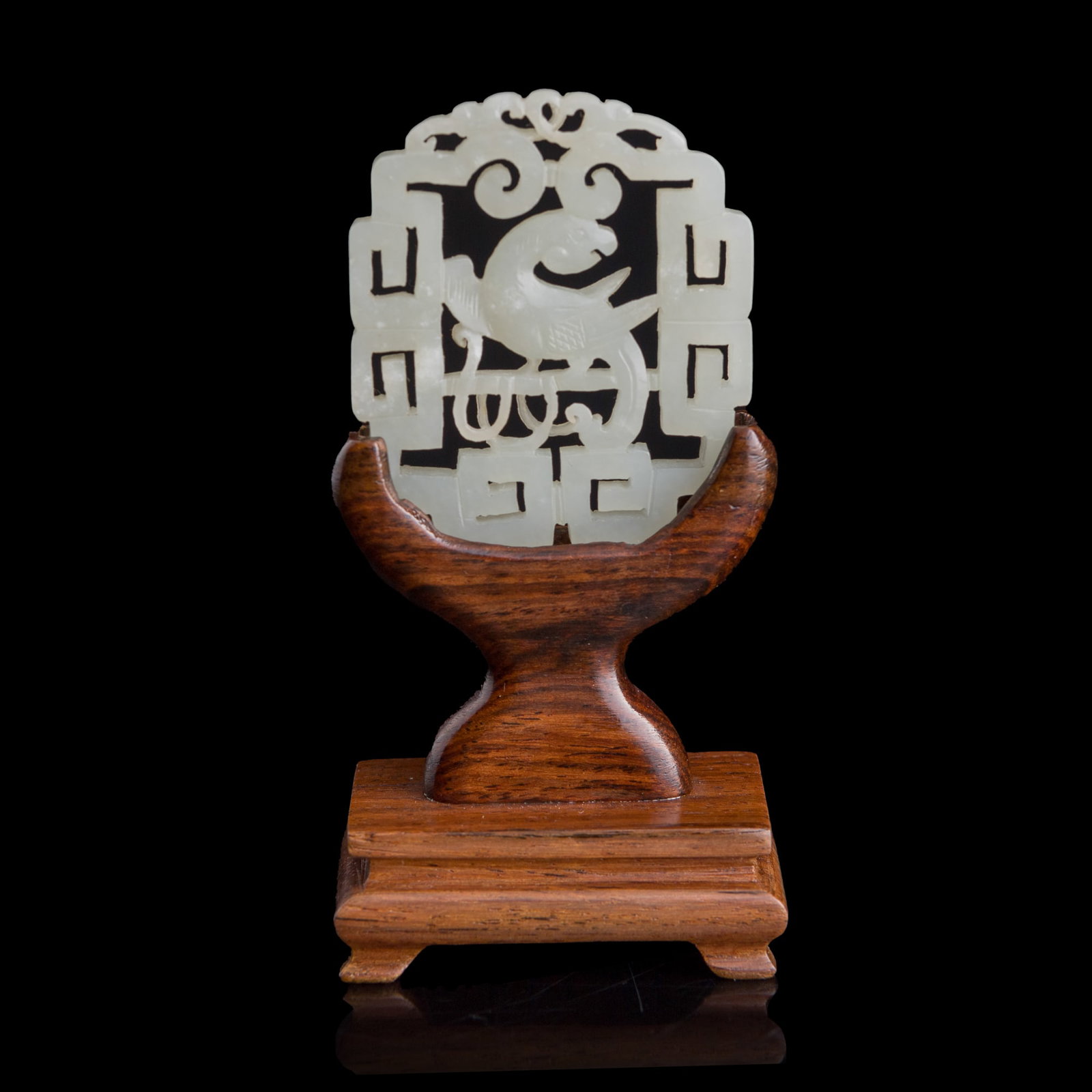 A Chinese reticulated white jade 'parrot' plaque, 18th century: A Chinese reticulated white jade 'parrot' plaque 18th century Sold with associated wooden stand. H: 2 1/8, W: 1 7/8, D: 3/16 in. (H: 5.4, W: 4.8, D: 0.5 cm. (jade)) From Mr. Tinero, Calabasas,