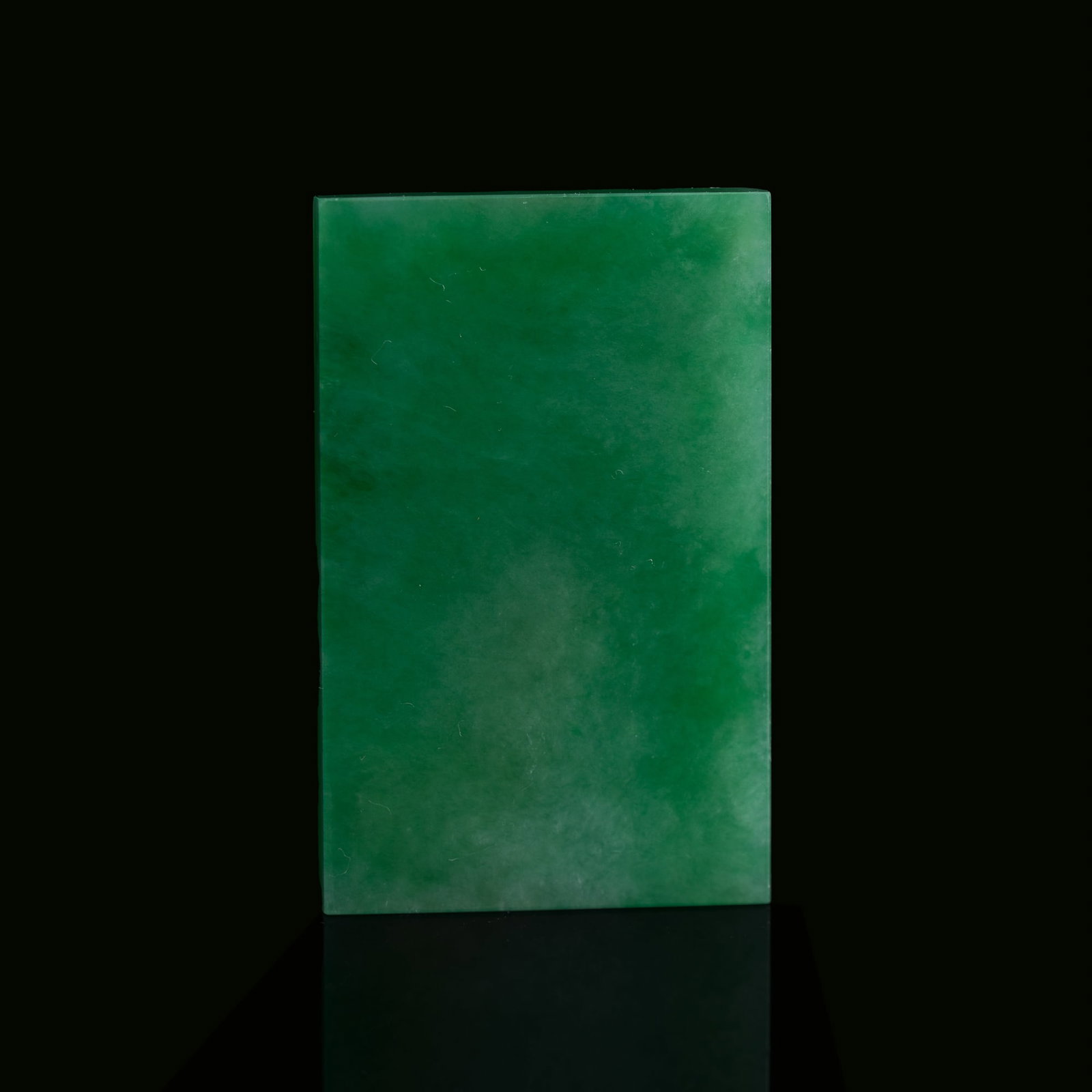 A Chinese plain jadeite plaque, Qing dynasty: A Chinese plain jadeite plaque Qing dynasty H: 1 7/8, W: 1 1/8, D: 1/8 in. (H: 4.8, W: 2.9, D: 0.3 cm.) From Mrs. Kiang in Newport Coast, California; collected by her late husband.