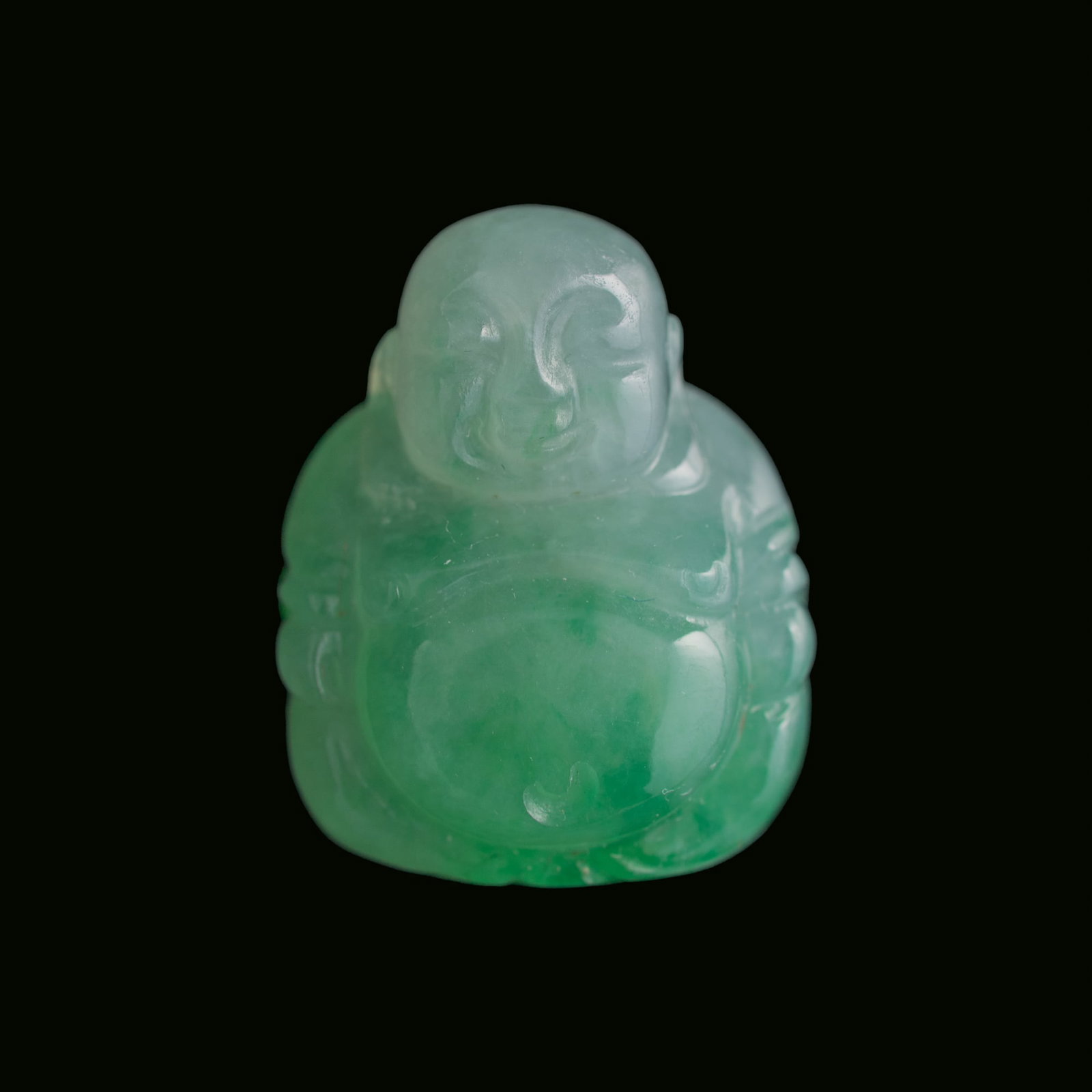 A Chinese jadeite carving of Maitreya Buddha: A Chinese jadeite carving of Maitreya Buddha H: 3/4, W: 5/8, D: 3/8 in. (H: 1.9, W: 1.6, D: 1 cm.) From Mrs. Kiang in Newport Coast, California; collected by her late husband.