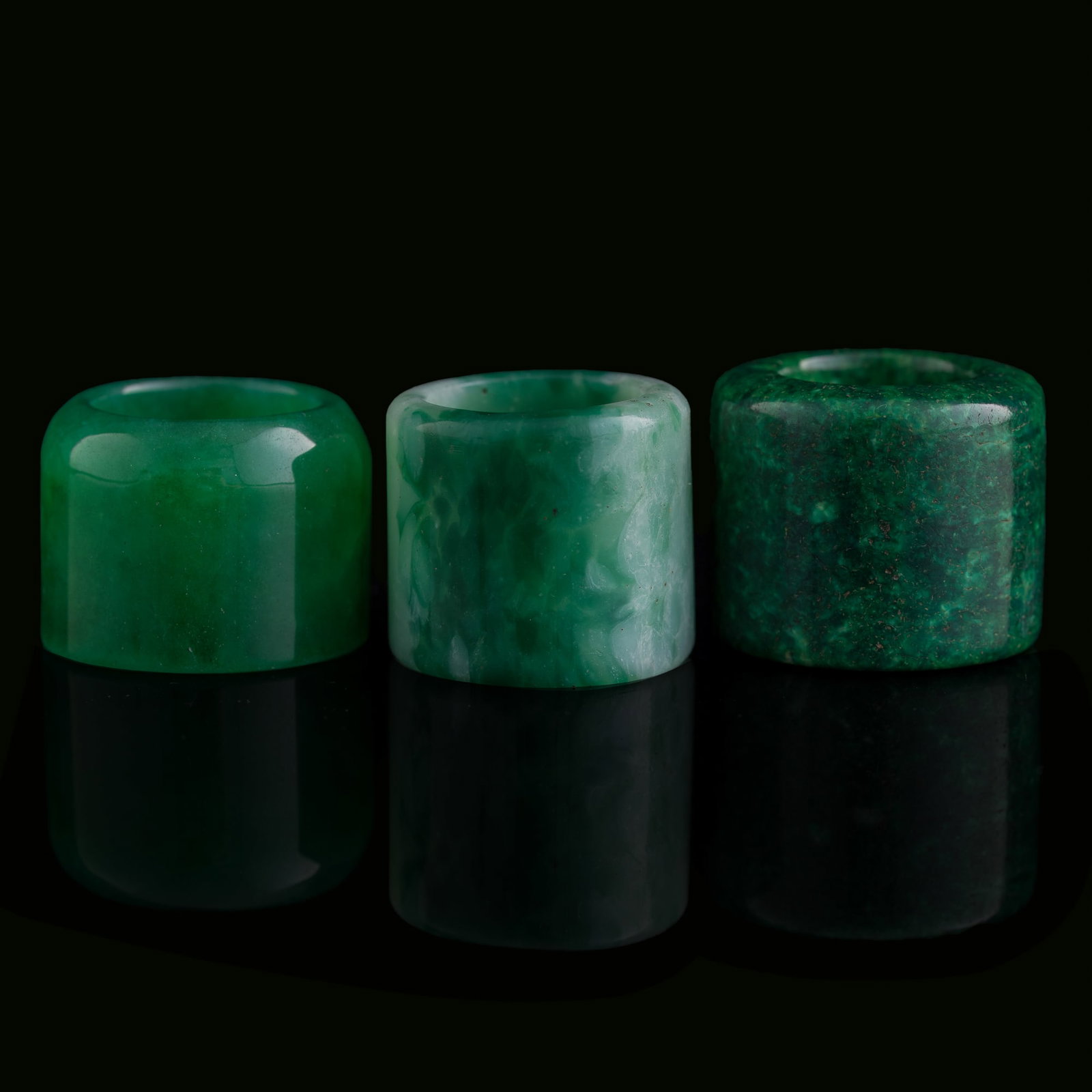 A Chinese glass and two jade archer's rings, Qing dynasty: A Chinese glass and two jade archer's rings Qing dynasty Comprising a glass archer's ring, a Dushan jade archer's ring, and a Guangning jade archer's ring. (3). Inner Dia.: 19.6, H: 28.7 mm.