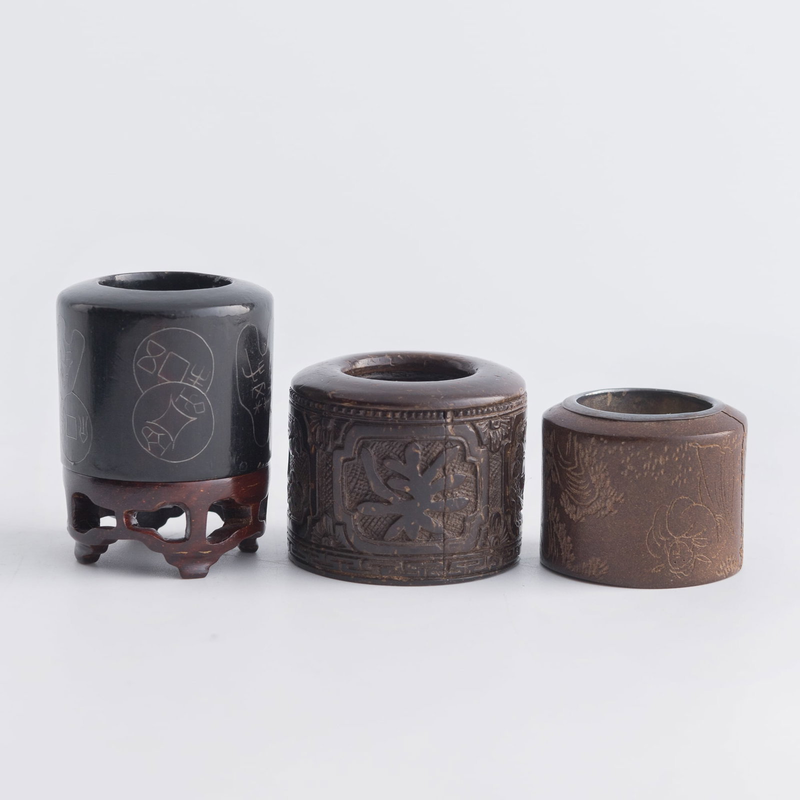 Three assorted Chinese archer's rings, Qing dynasty: Three assorted Chinese archer's rings Qing dynasty One with "Xie Fuchun" mark to the interior. Sold with one associated wooden stand. (3). Inner Dia.: 20 mm, H: 30 mm (largest) From Mrs. Kiang in