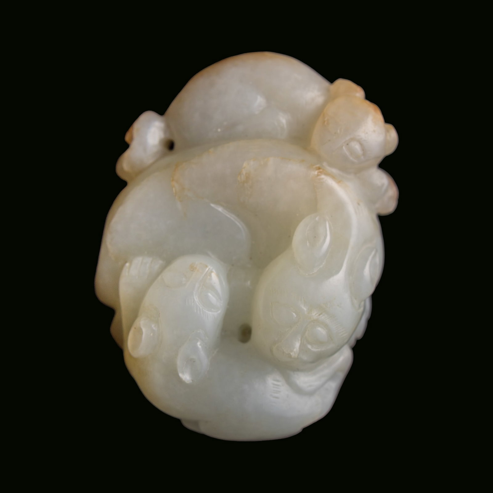 A Chinese carved jade pendant of three badgers, 18th/19th century: A Chinese carved jade pendant of three badgers 18th/19th century H: 1 3/8, W: 2, D: 5/8 in. (H: 3.5, W: 5.1, D: 1.6 cm.) From Mrs. Kiang in Newport Coast, California; collected by her late husband.