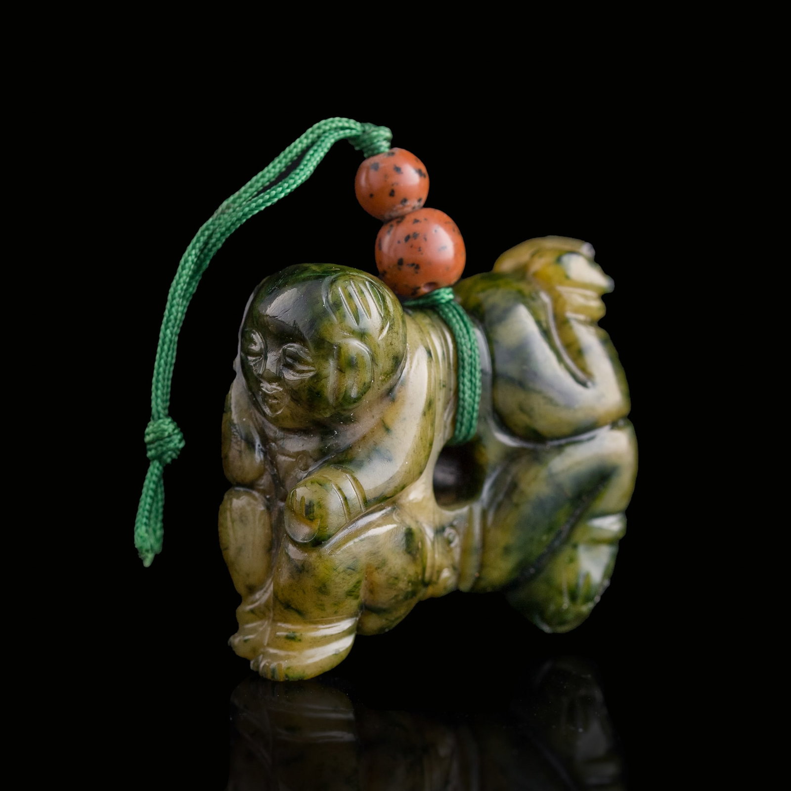 A Chinese carved spinach jade pendant of two boys, Ming dynasty: A Chinese carved spinach jade pendant of two boys Ming dynasty H: 1 1/2, W: 1 3/8, D: 5/8 in. (H: 3.8, W: 3.5, D: 1.6 cm.) From Mrs. Kiang in Newport Coast, California; collected by her late husband.