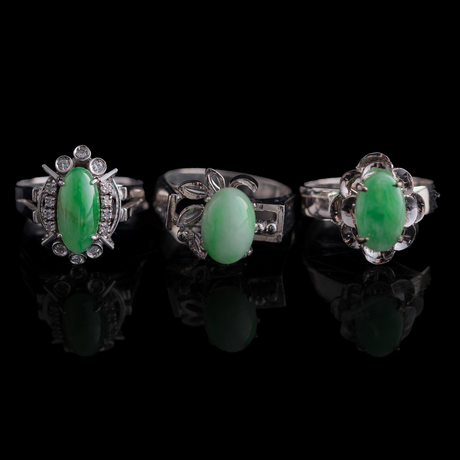 Three Chinese jadeite-set white metal rings: Three Chinese jadeite-set white metal rings One stamped "77P" or "11P" to interior, one stamped "ba hejin" to interior. (3). Inner Dia.: 16.7 mm (largest) Jadeite: H: 11, W: 5.3 mm (largest) Weight: