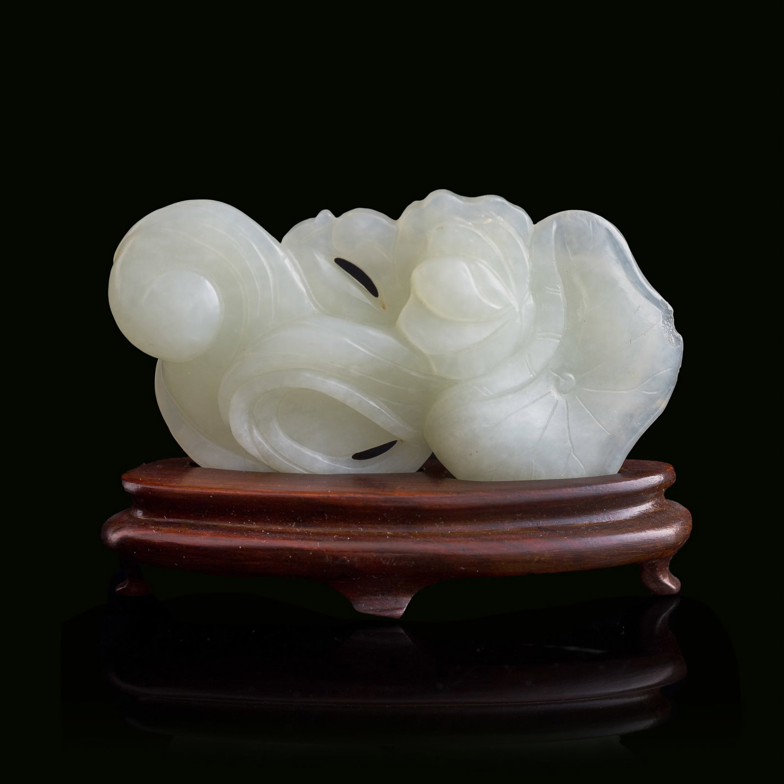 A Chinese white jade 'catfish' pendant, 19th century: A Chinese white jade 'catfish' pendant 19th century Sold with associated wooden stand. H: 1 3/4, W: 3, D: 5/8 in. (H: 4.4, W: 7.6, D: 1.6 cm. (pendant)) From Mr. Chen, Great Neck, New York; acquired p