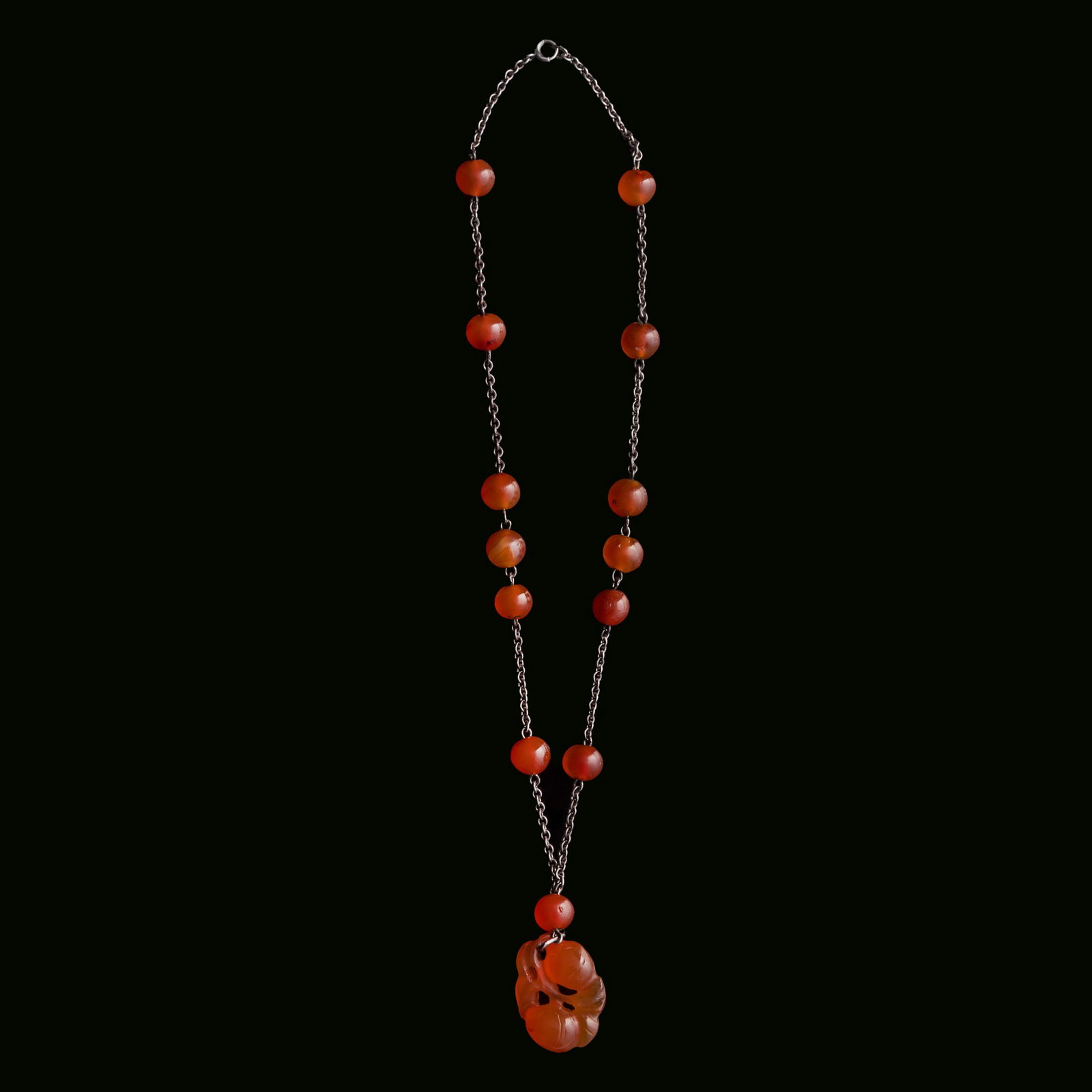 A Chinese necklace composed of agate beads and pendant, 19th century: A Chinese necklace composed of agate beads and pendant 19th century L: 9 5/8 in. (24.4 cm.) Pendant: H: 1 1/8, W: 7/8, D: 1/2 in. (H: 2.9, W: 2.2, D: 1.3 cm.) From Mr. Kaufman in Arlington, Virginia; 