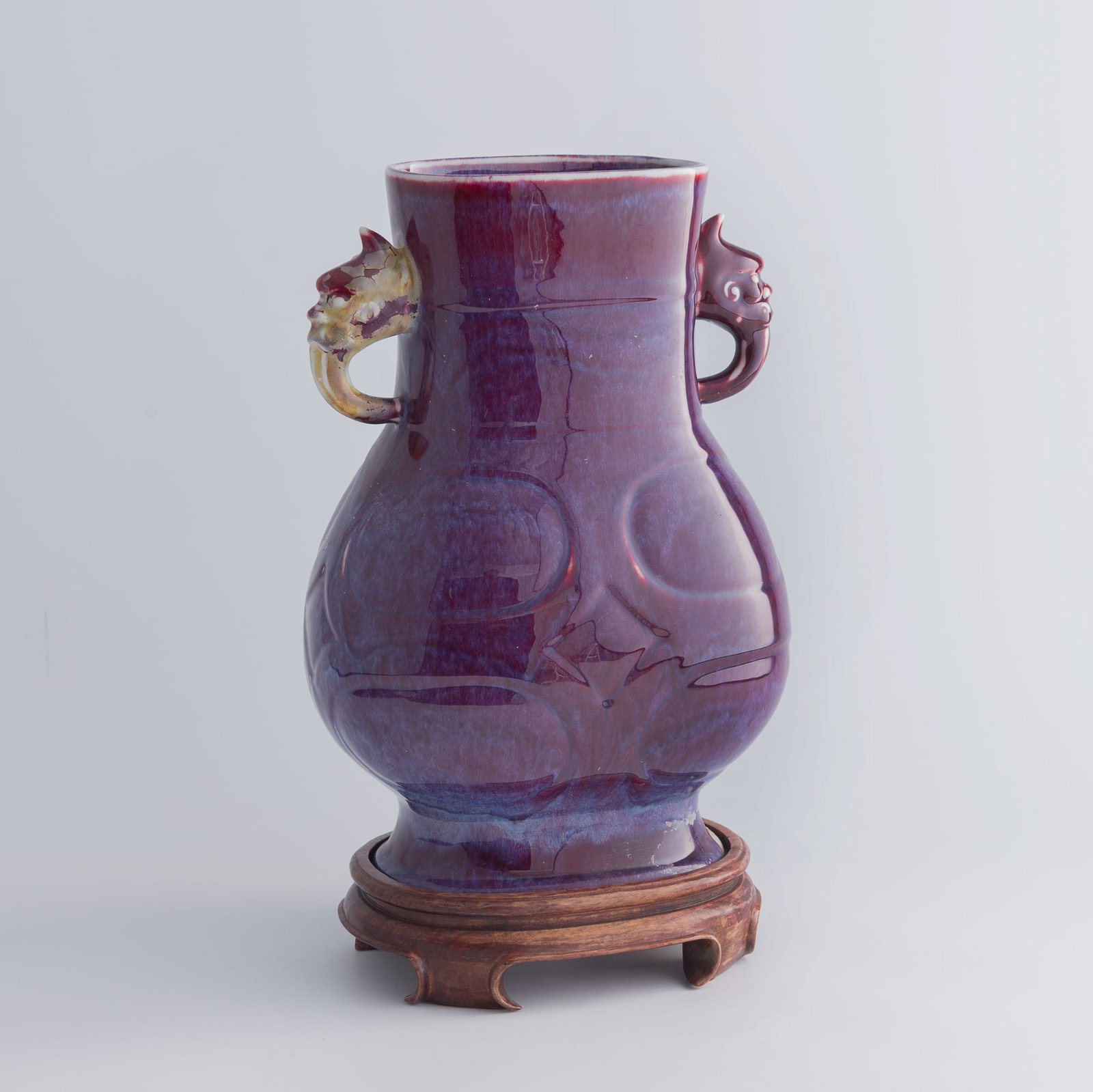 A Chinese flambe double-handled vase, late 19th century: A Chinese flambe double-handled vase late 19th century Sold with associated wooden stand. H: 13 1/8, W: 9 1/8, D: 7 in. (H: 33.3, W: 23.2, D: 17.8 cm. (vase)) Private collection, Atlanta, Georgia.