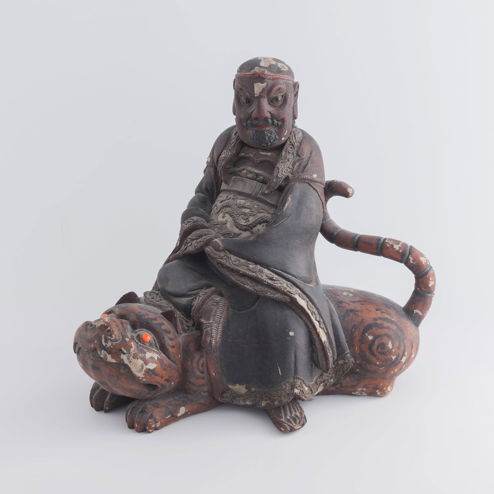 A Chinese lacquered wood figure of Zhao Gongming, God of Wealth, riding a tiger, late 18th/early: A Chinese lacquered wood figure of Zhao Gongming, God of Wealth, riding a tiger late 18th/early 19th century H: 15 5/8, W: 17 3/8, D: 10 1/4 in. (H: 39.7, W: 44.1, D: 26 cm.) Private estate, Washingto