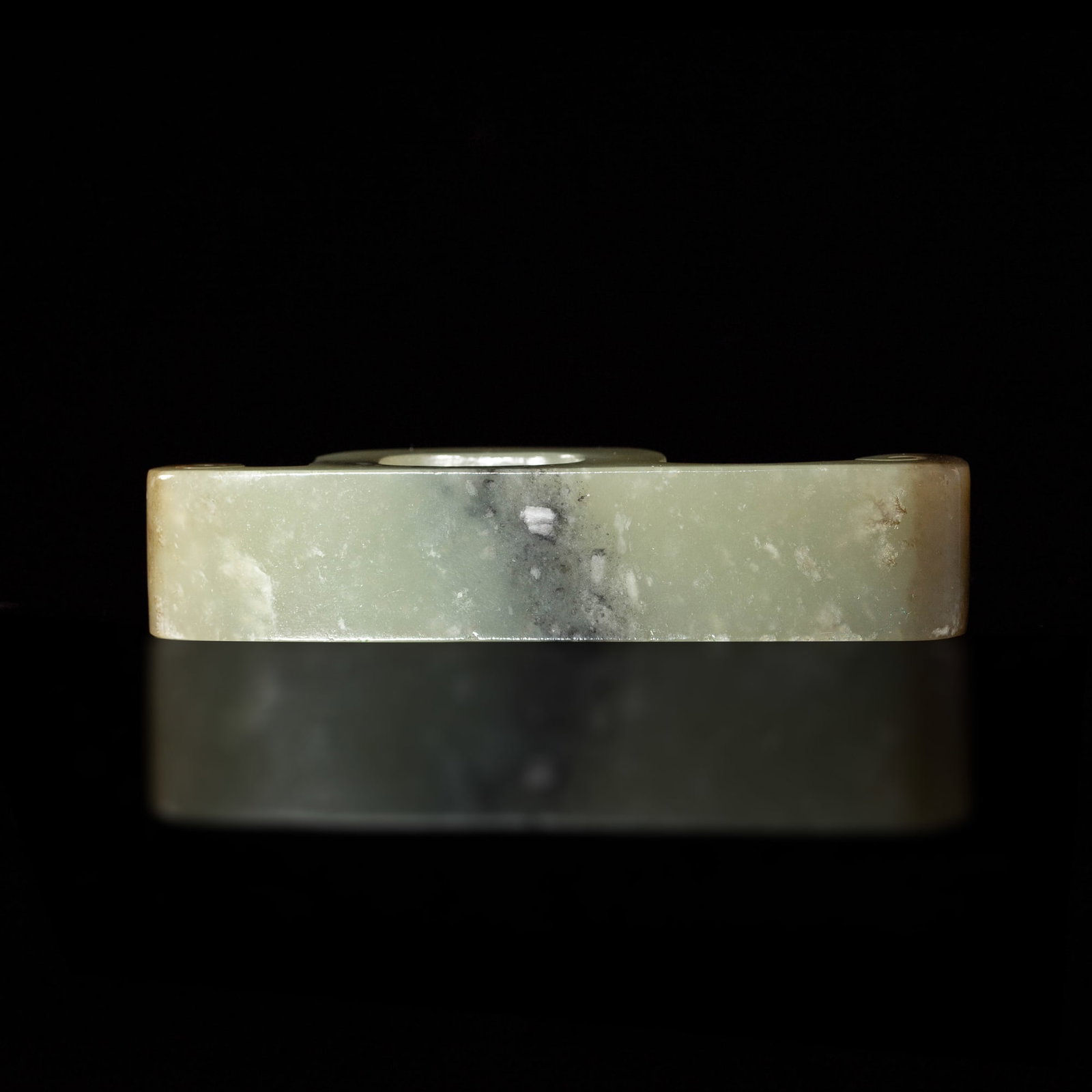 A Chinese celadon jade sword fitting, Ming dynasty or earlier: A Chinese celadon jade sword fitting Ming dynasty or earlier With carved, slightly raised stud details. H: 3/4, W: 3 1/2, D: 1 1/8 in. (H: 1.9, W: 8.9, D: 2.9 cm.) Mrs. Chang, Newport Beach, Californi