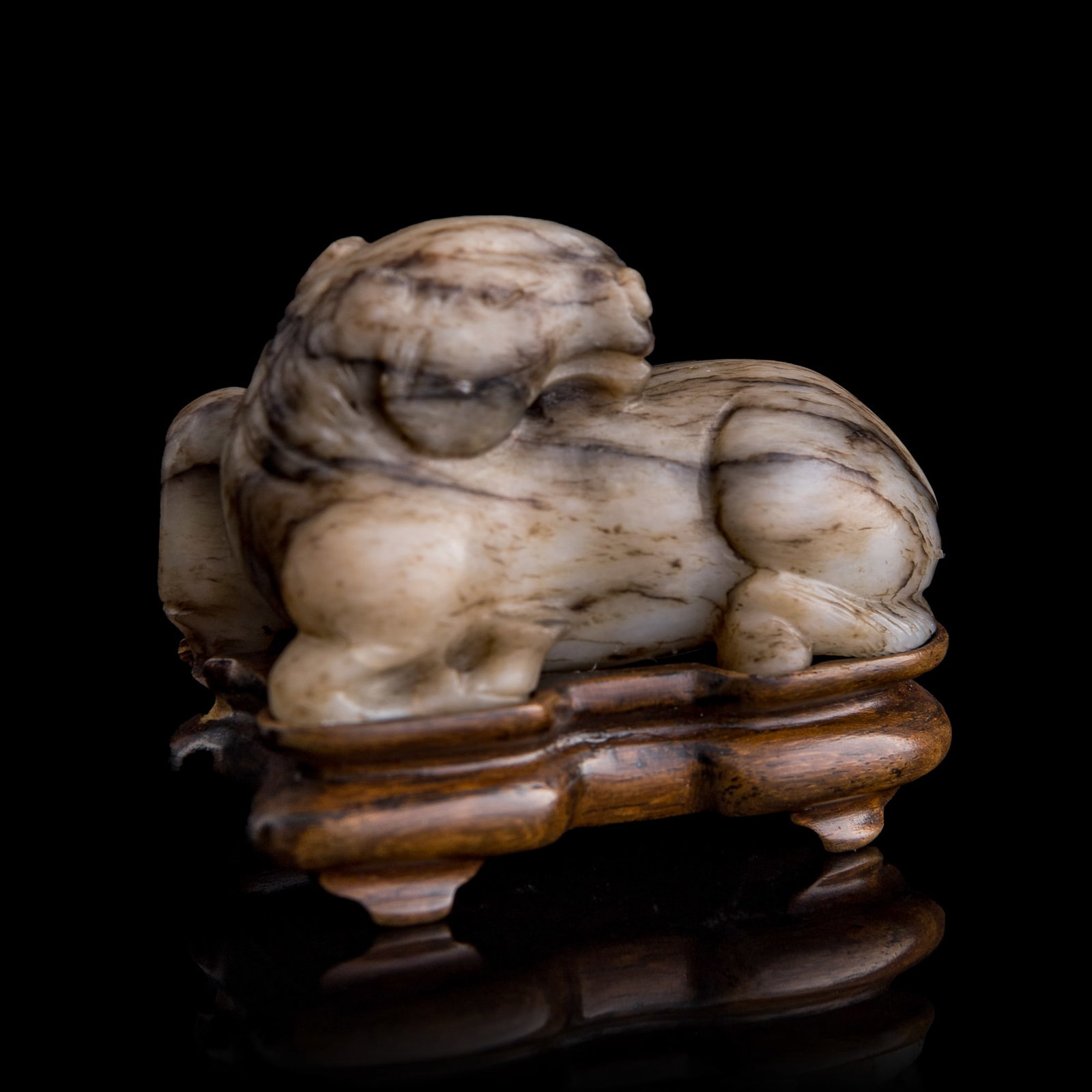 A Chinese jade recumbent horse, Ming dynasty: A Chinese jade recumbent horse Ming dynasty Bearing a collection label from The Jade Dragon, an antique shop in Ann Arbor, Michigan, numbered 17266. Sold with associated hardwood stand. H: 2 1/4, W: 2