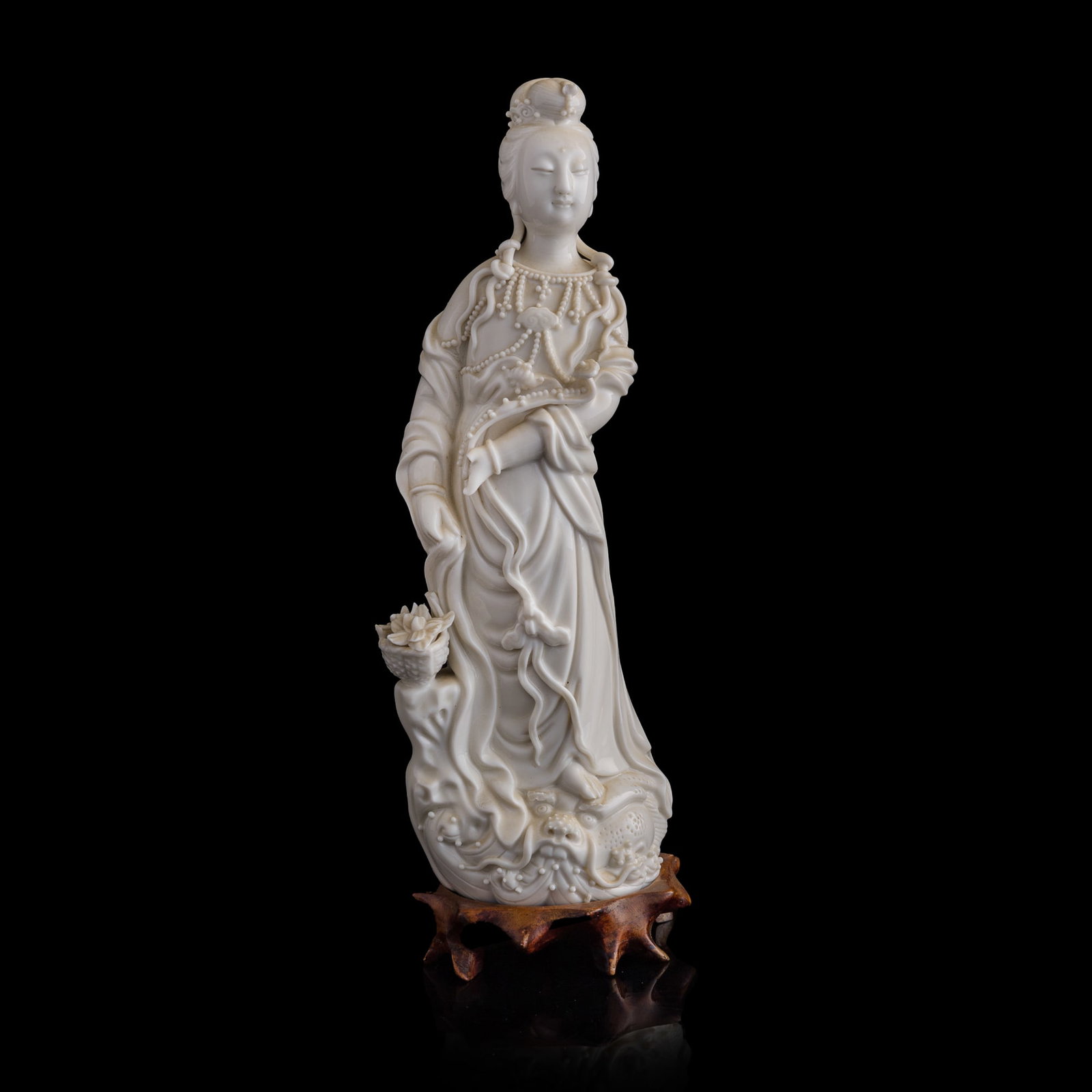 A Chinese Dehua figure of Guanyin, 19th century: A Chinese Dehua figure of Guanyin 19th century With a hulu-form mark to the back. Sold with original fitted brocade box and a stand. Also accompanied by an old note, possibly written by its original o