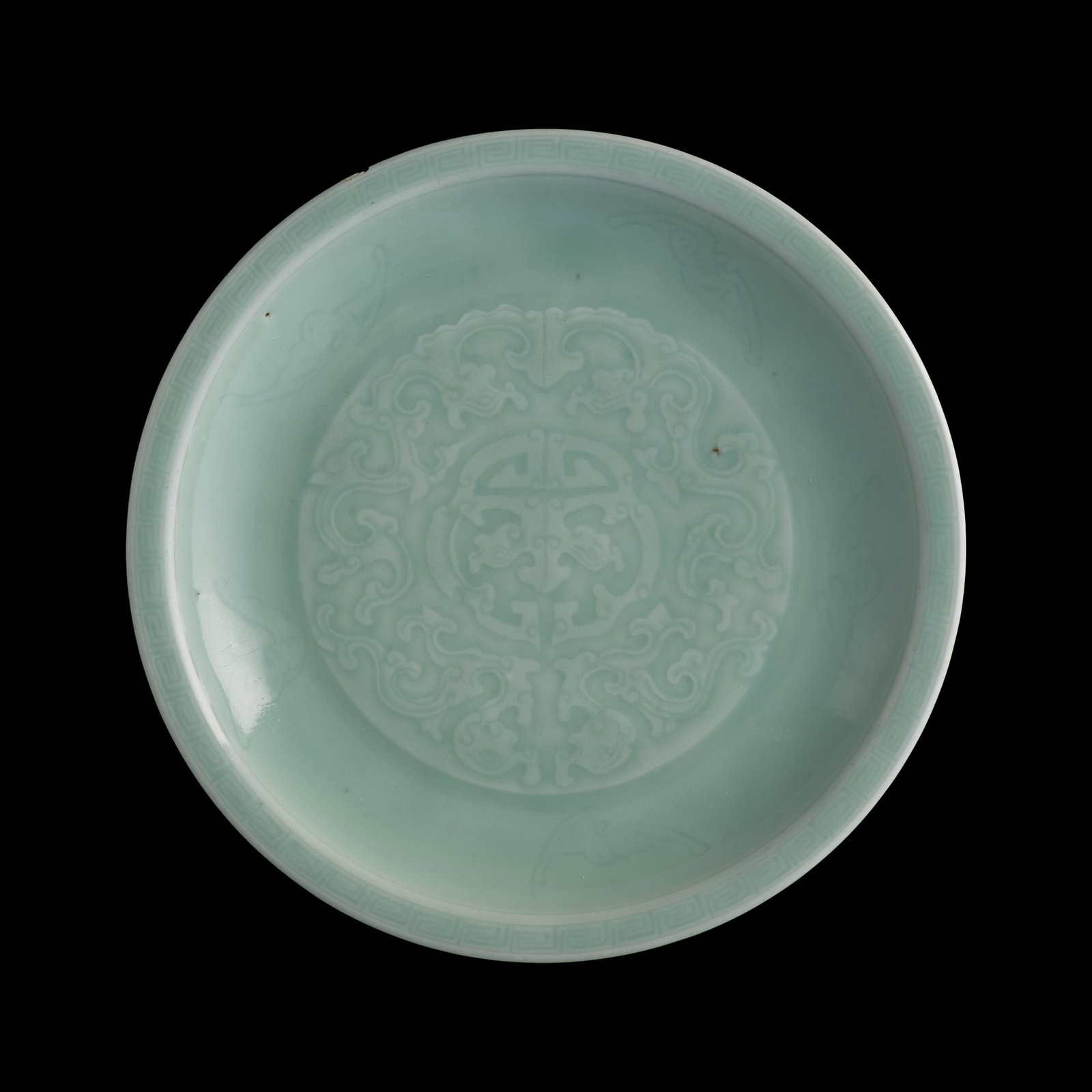 A Chinese celadon molded 'kui-dragon' plate, Qianlong period, Qing dynasty: A Chinese celadon molded 'kui-dragon' plate Qianlong period, Qing dynasty With six-character Qianlong mark to underside. H: 1 5/8, Dia: 11 in. (H: 4.1, Dia: 27.9 cm.) From Mrs. Wong, Beverly Hills, Ca