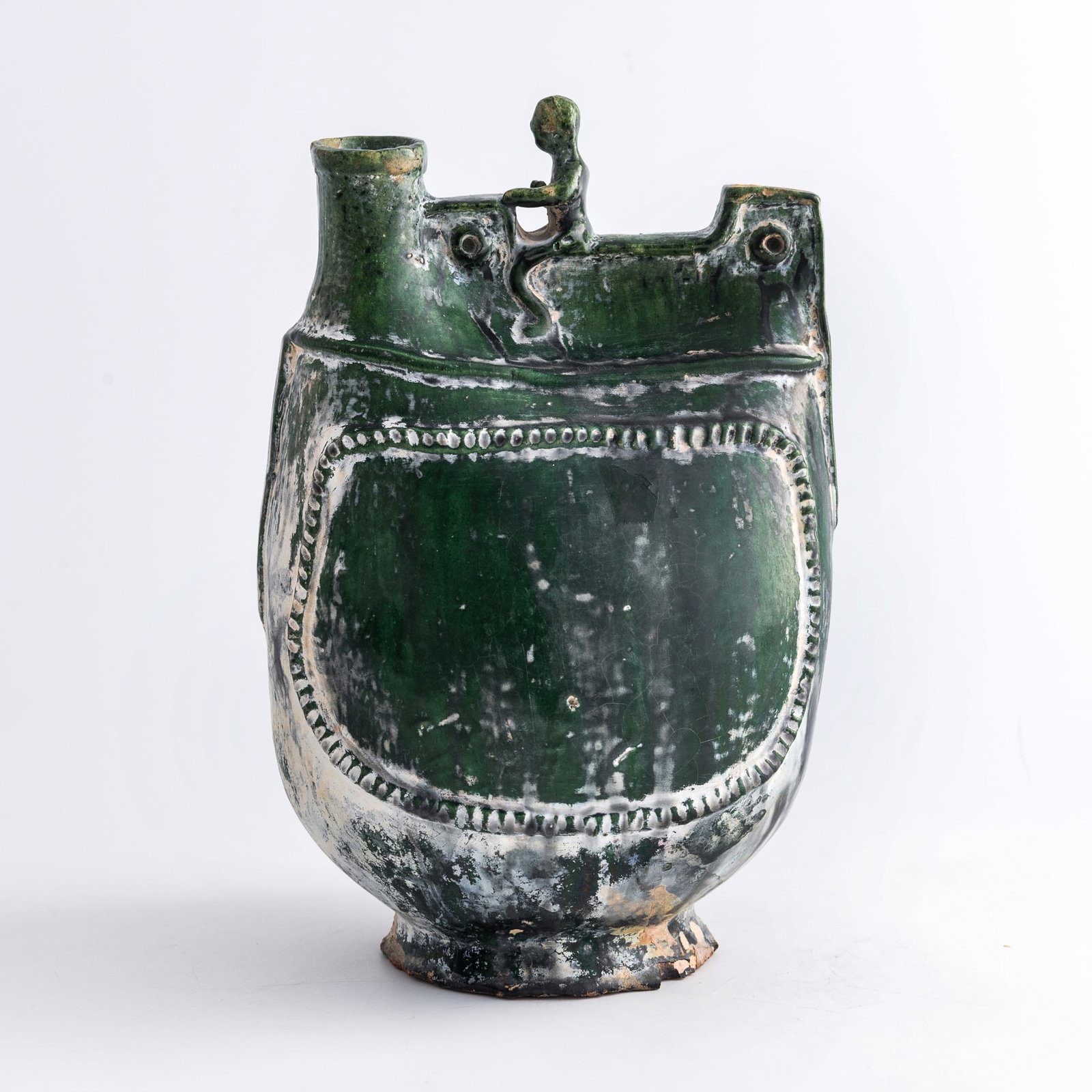 A Chinese green-glazed leather-bag-form ewer, Liao/Jin dynasty: A Chinese green-glazed leather-bag-form ewer Liao/Jin dynasty H: 9 1/2, W: 6 3/8, D: 5 1/4 in. (H: 24.1, W: 16.2, D: 13.3 cm.) Private collection, Irvine, California.