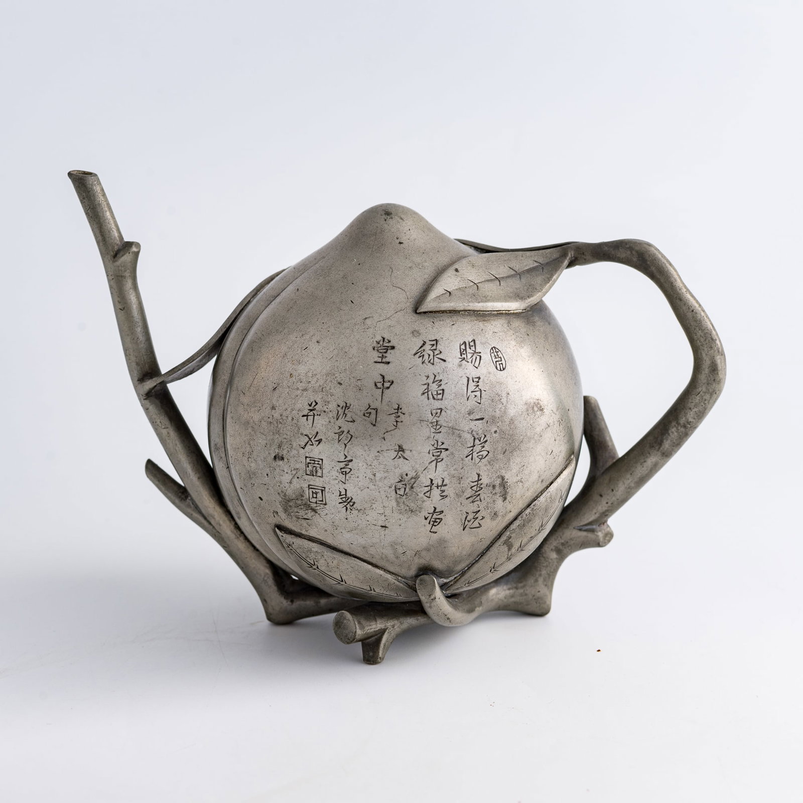 A Chinese pewter peach-form reverse-flow ewer, by Shen Langting, Qianlong period, Qing dynasty: A Chinese pewter peach-form reverse-flow ewer by Shen Langting, Qianlong period, Qing dynasty With an inscription and three seals, the signature reading "Made and inscribed by Shen Langting." H: 5 1/4