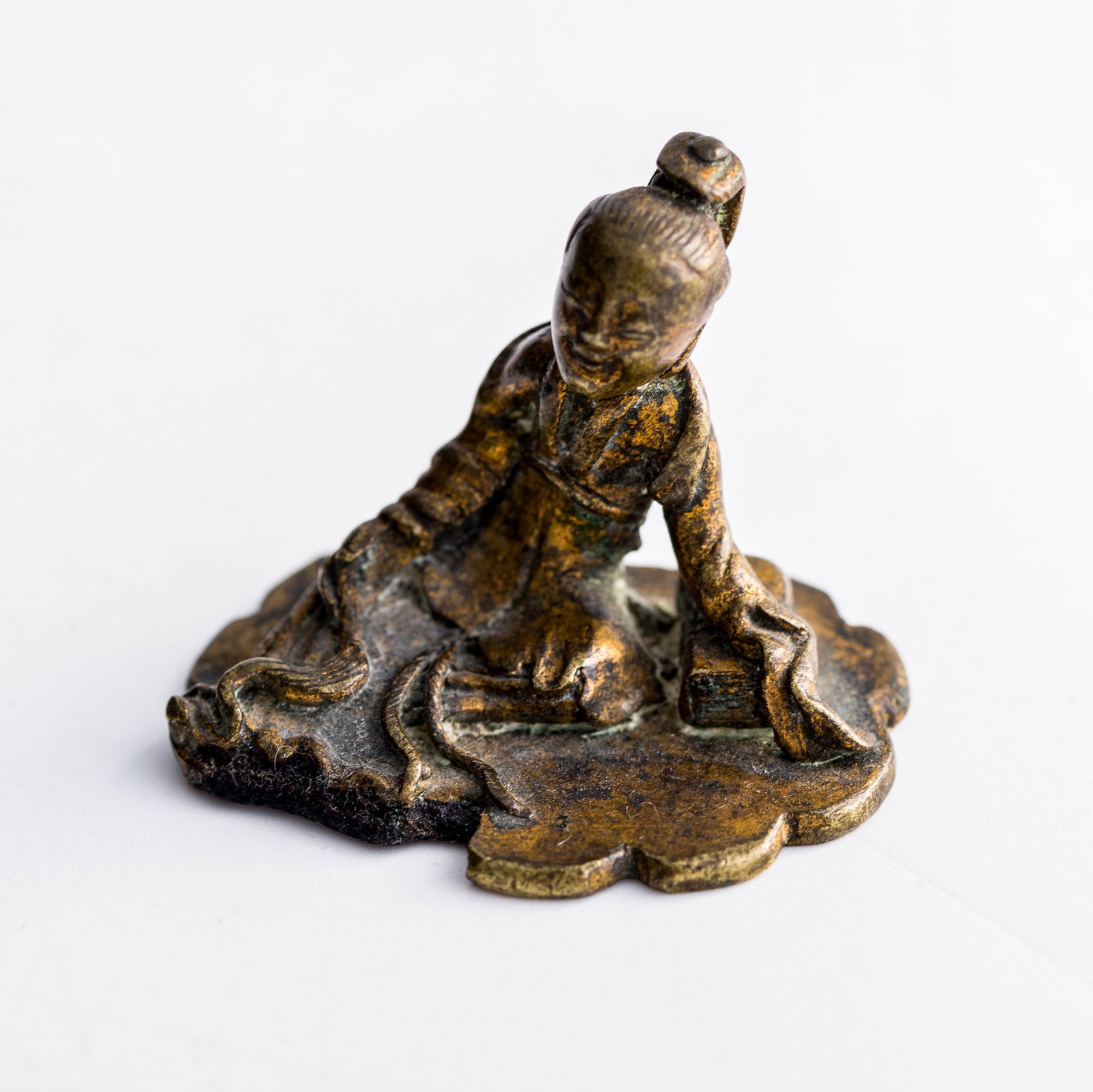 A Chinese gilt-bronze scholar-form paperweight, Ming dynasty: A Chinese gilt-bronze scholar-form paperweight Ming dynasty H: 1 3/8, W: 1 3/4, D: 1 3/8 in. (H: 3.5, W: 4.4, D: 3.5 cm.) Weight: 53.69 g Private collection, New York.